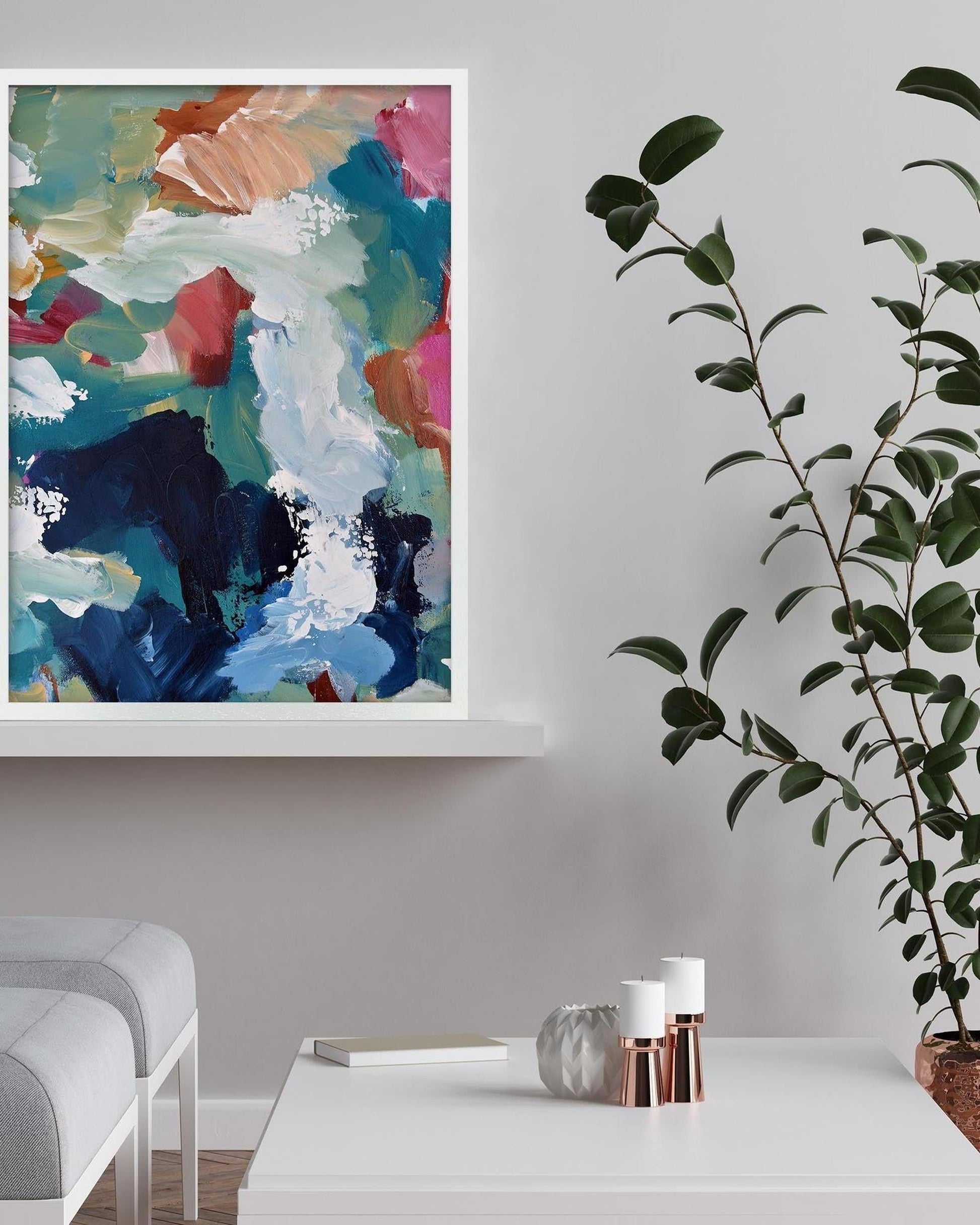 Modern living room with abstract art, a plant, and decorative items on a table.