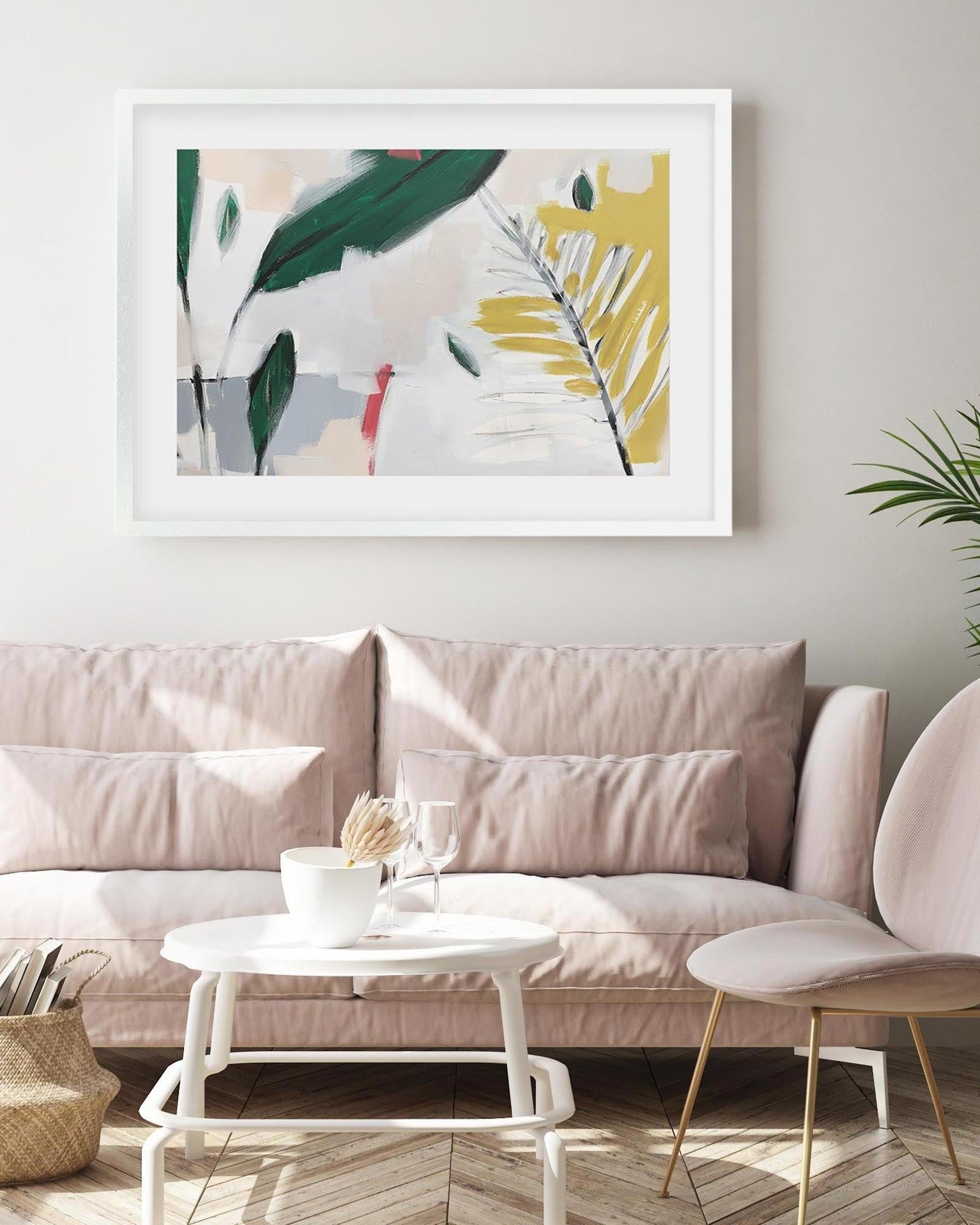 Framed abstract art above a beige sofa in a living room setting.