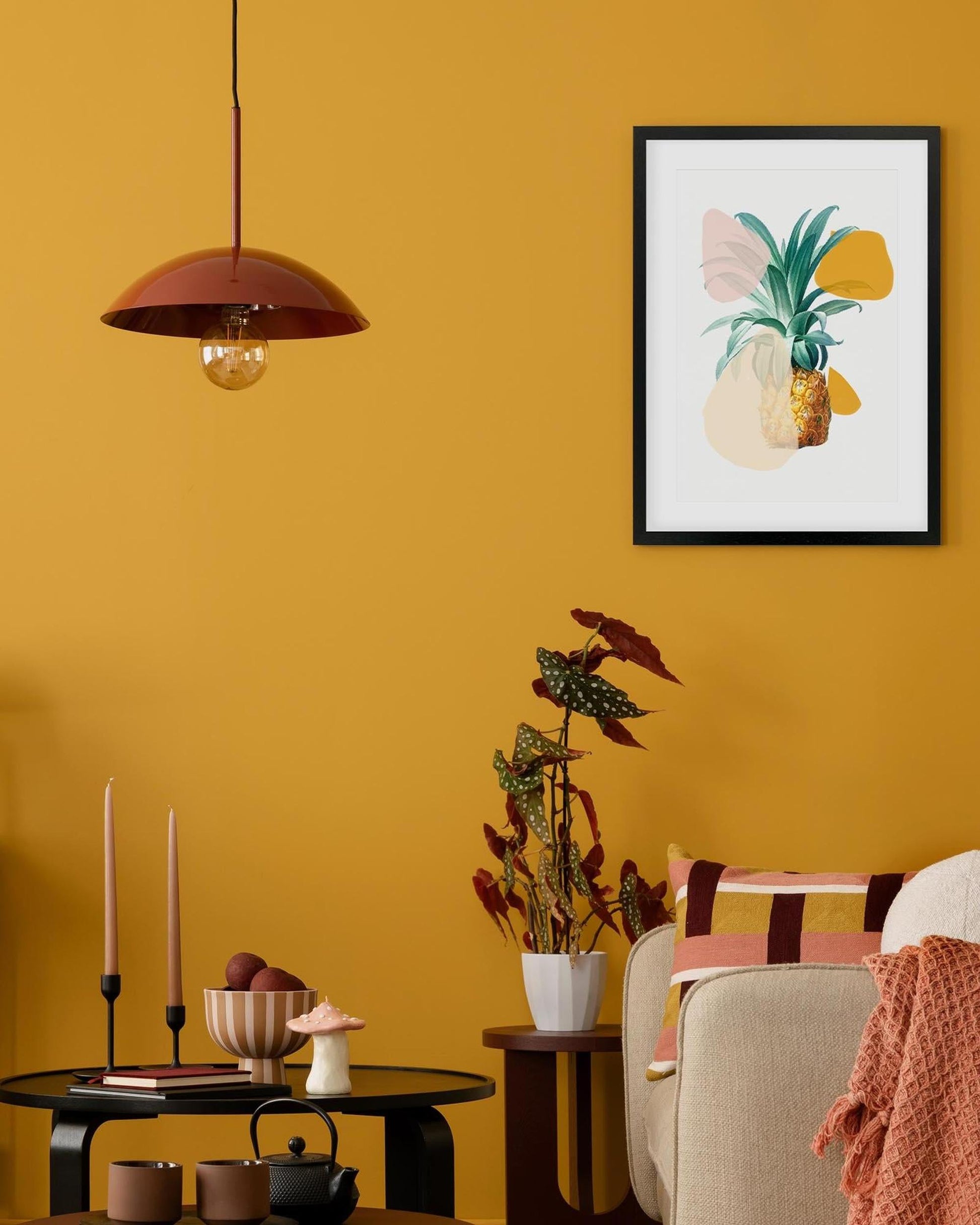 Living room with a yellow wall, framed artwork, and decorative items.