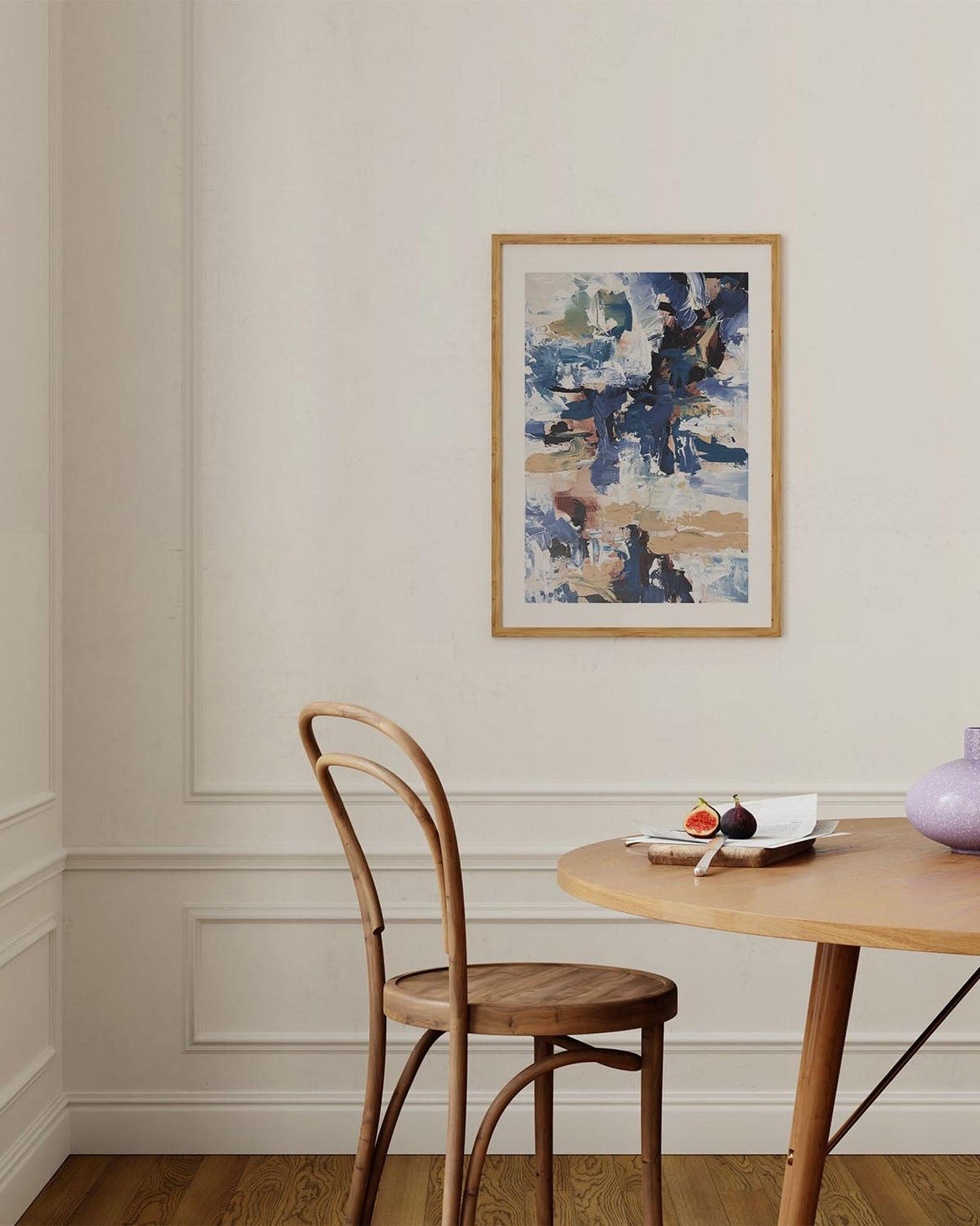 Dining room with wooden chair, table, and abstract painting on the wall.