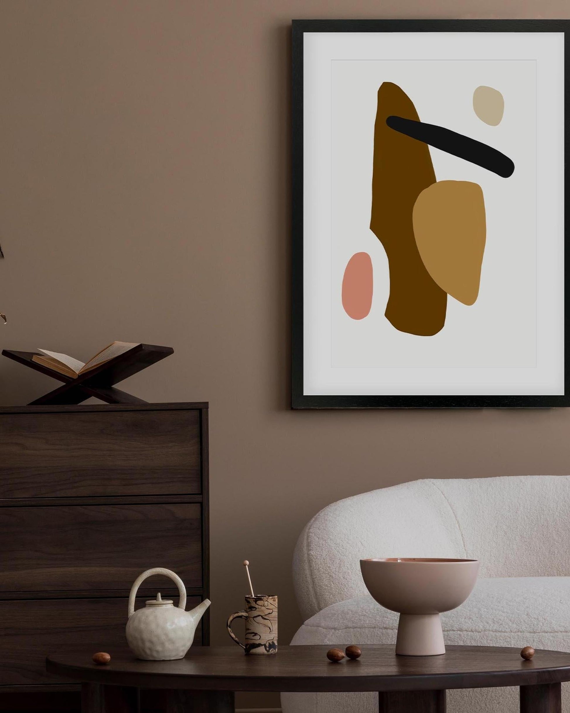 Abstract art print on a wall in a room with furniture and decor.