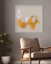 Abstract art piece on a wall above a chair and plant