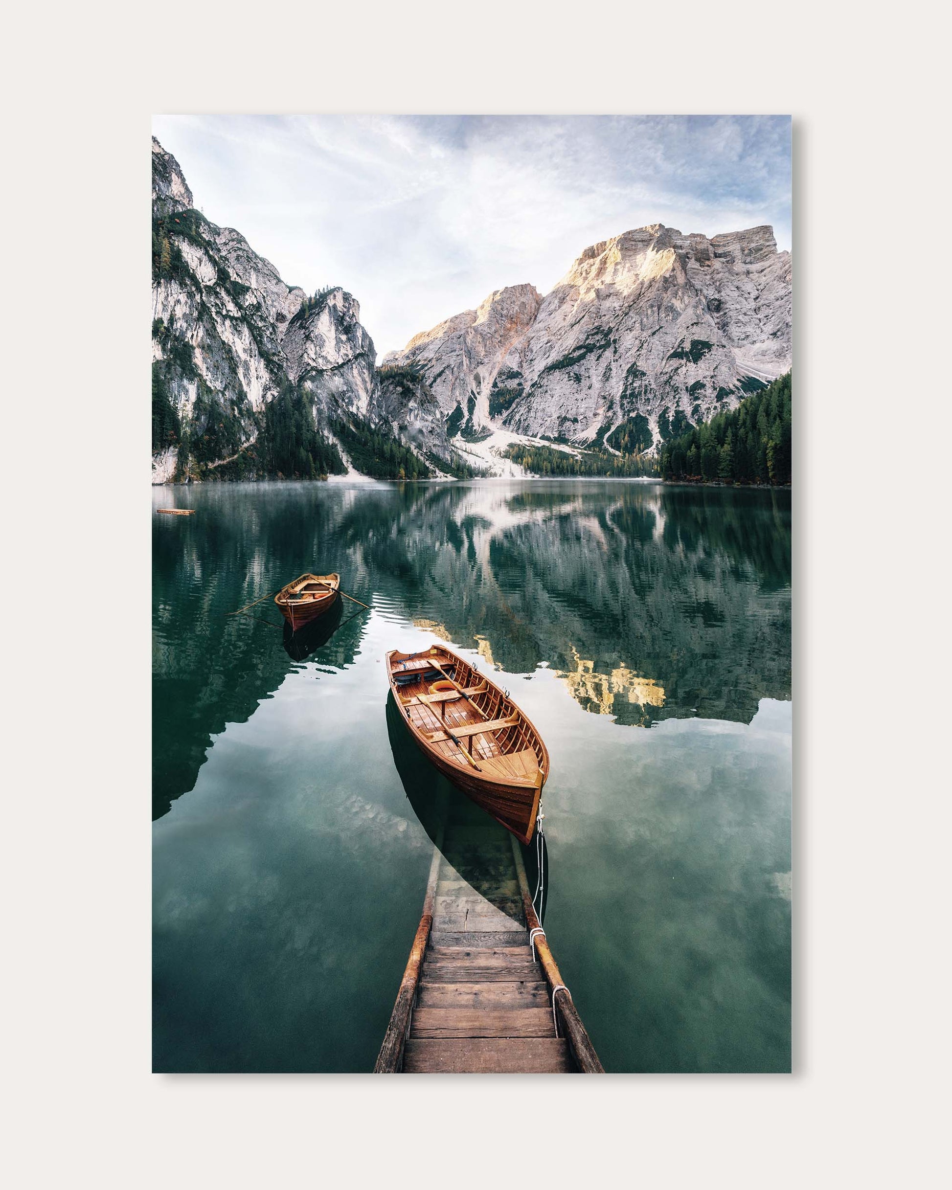 Two wooden boats on a calm lake with mountains in the background
