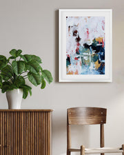 Room interior with a plant, wooden cabinet, and abstract art on the wall.