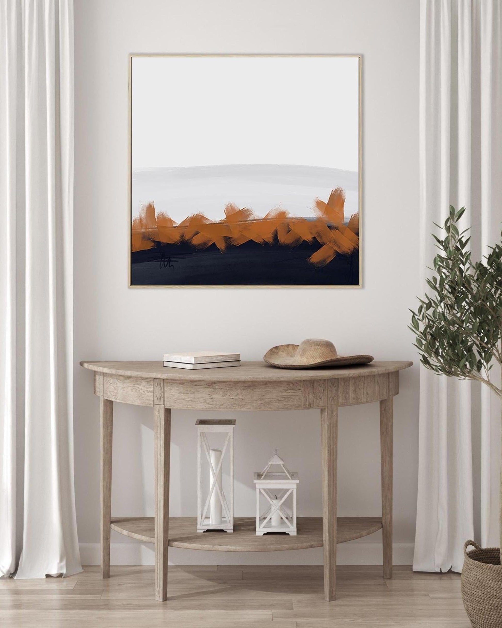 Wooden console table with decorative items against a white wall with a framed abstract art piece.