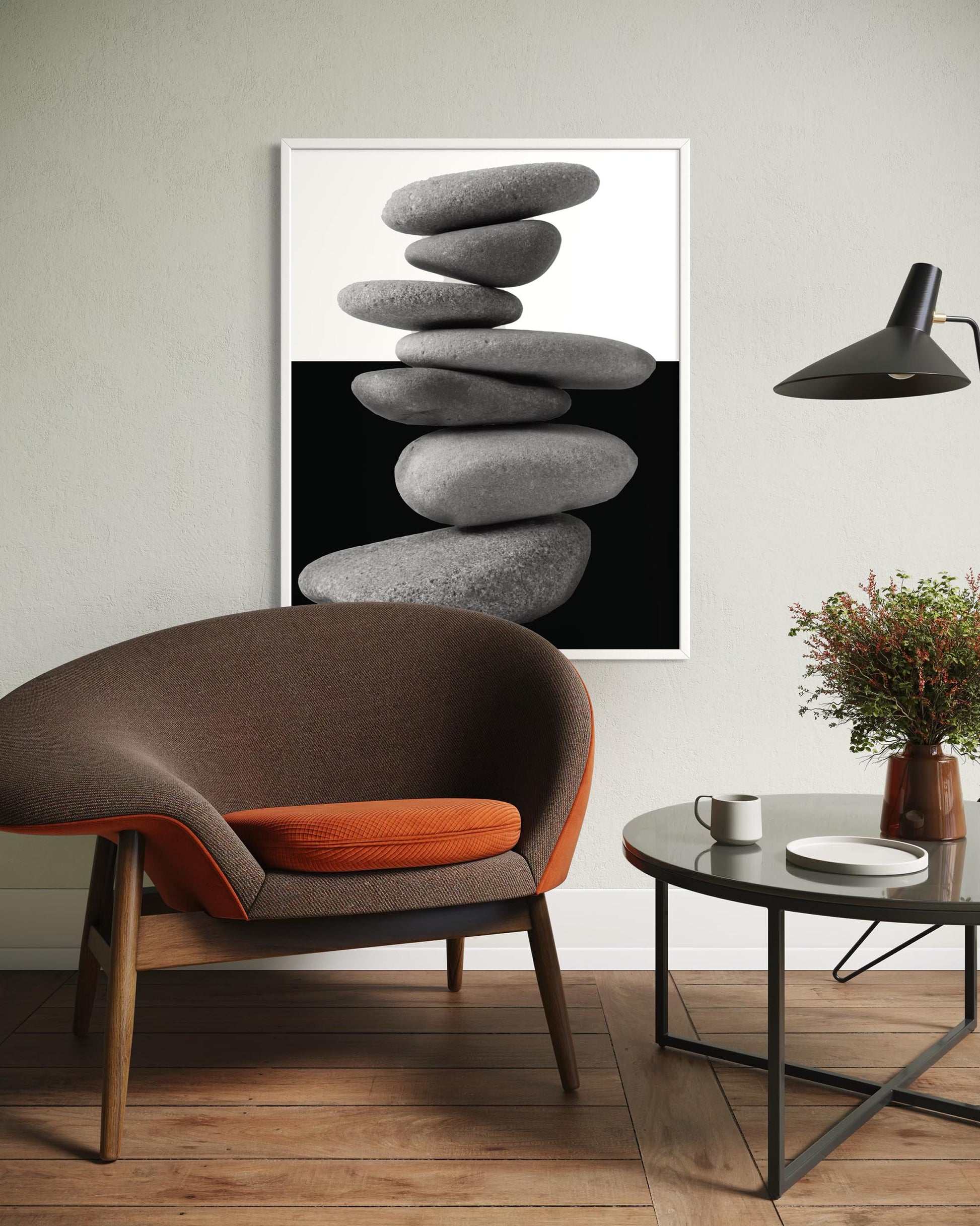 Modern interior with a brown and orange chair, coffee table, and abstract art of stacked stones.