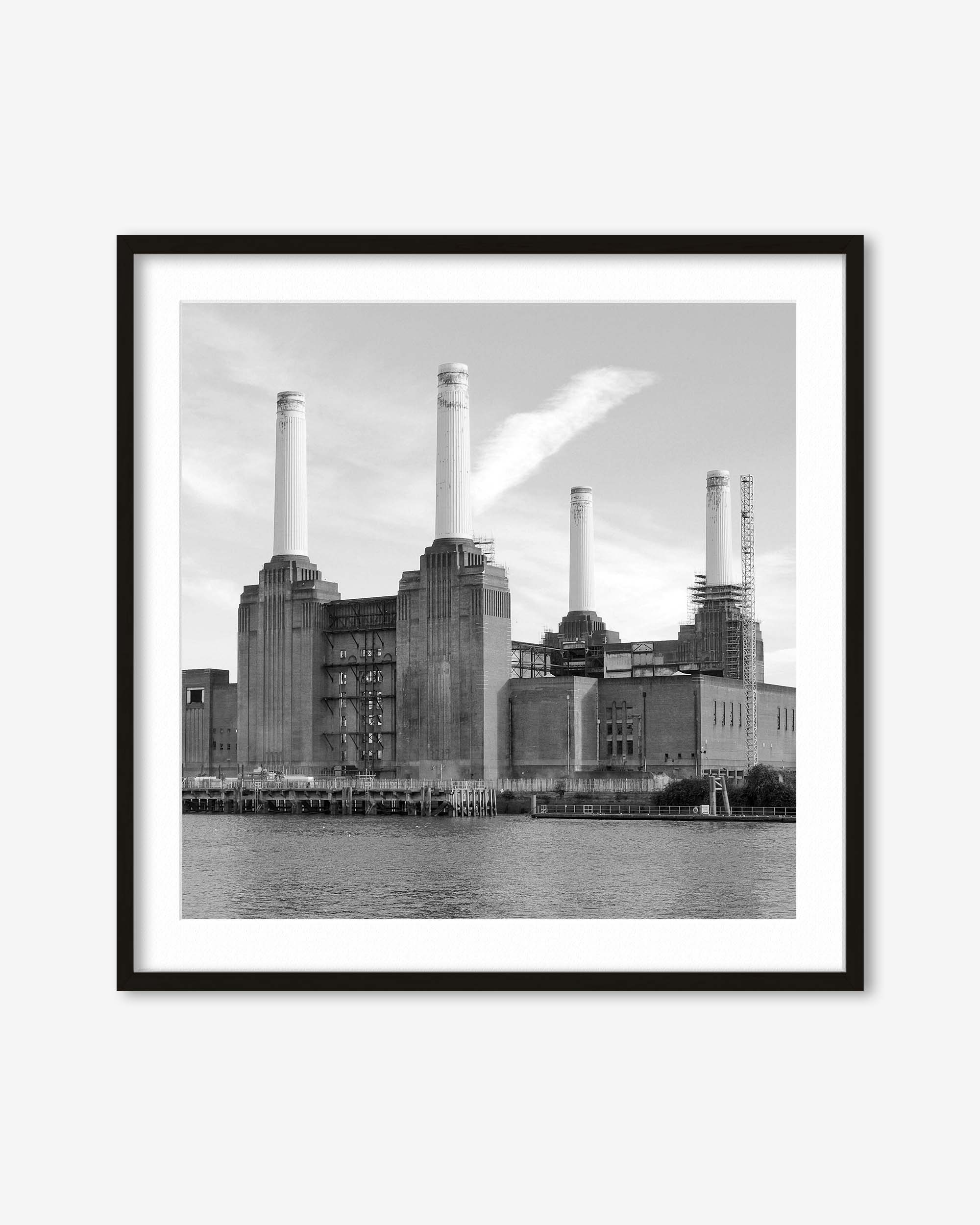 Framed black and white photograph of a industrial building with smokestacks by a body of water.