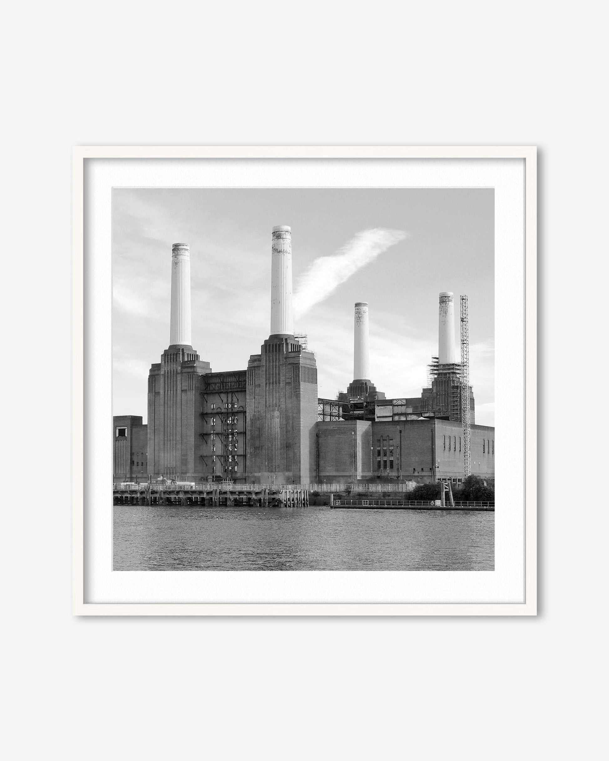 Framed black and white photograph of a industrial building with smokestacks by a body of water.