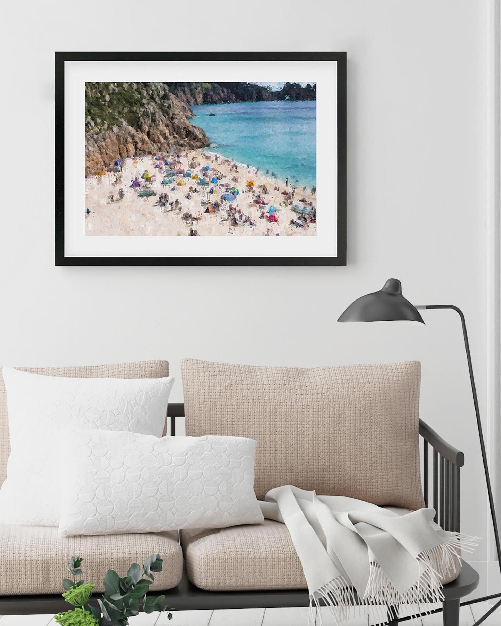 Framed photograph of a beach scene above a sofa in a living room.