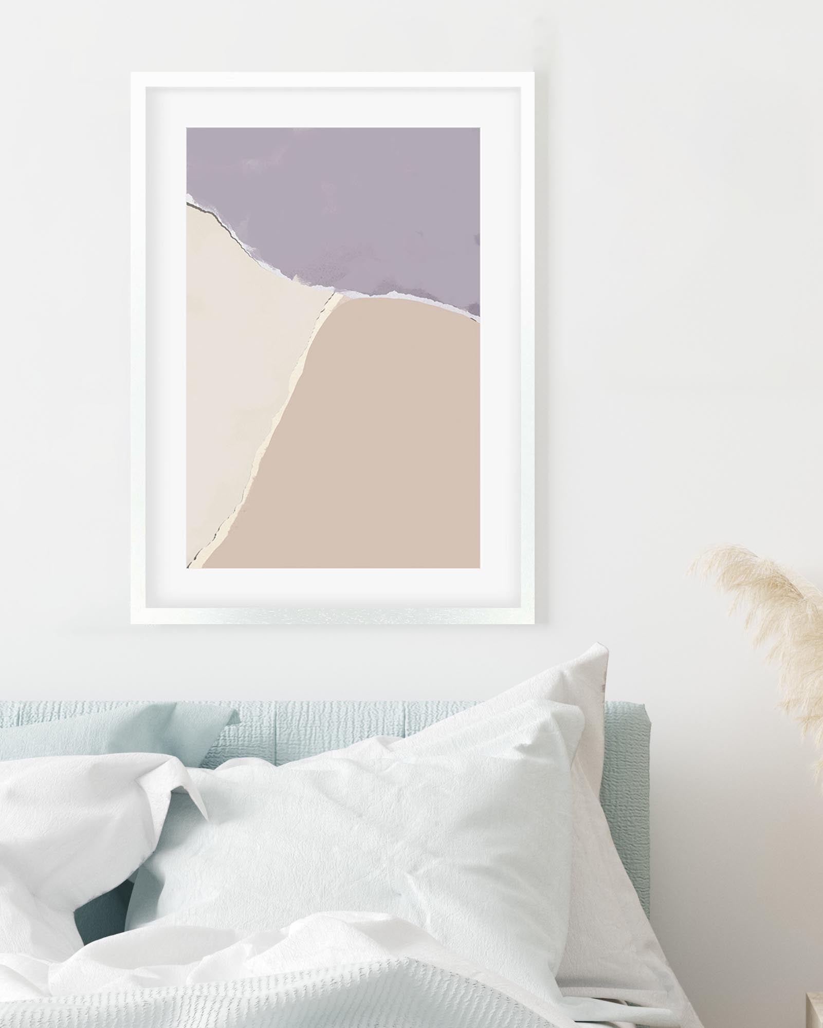 Framed abstract art print with purple and beige colors on a white wall.