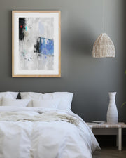 Modern bedroom with abstract art, pendant light, and vase.