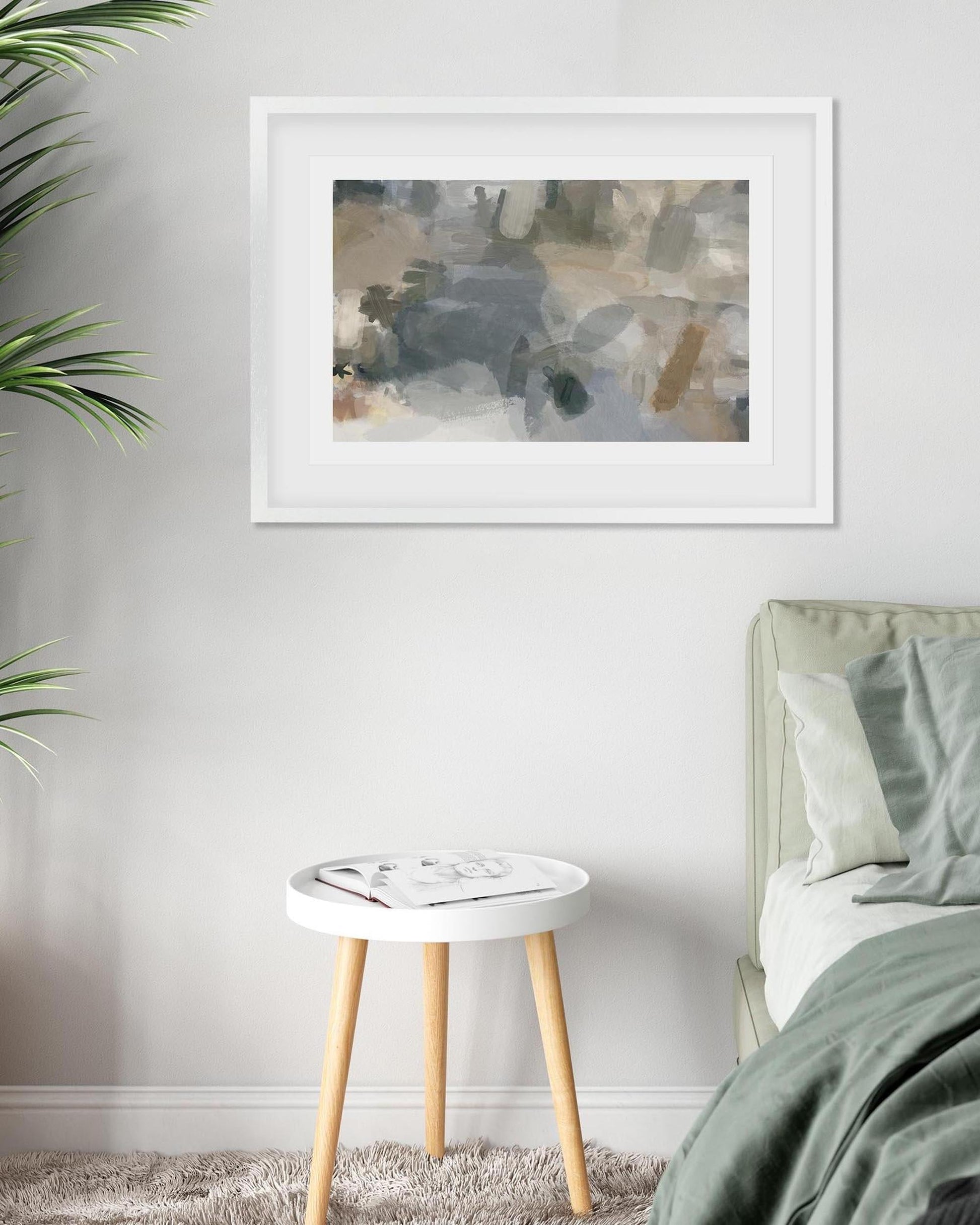 Framed abstract art on a wall above a bed in a bedroom setting.