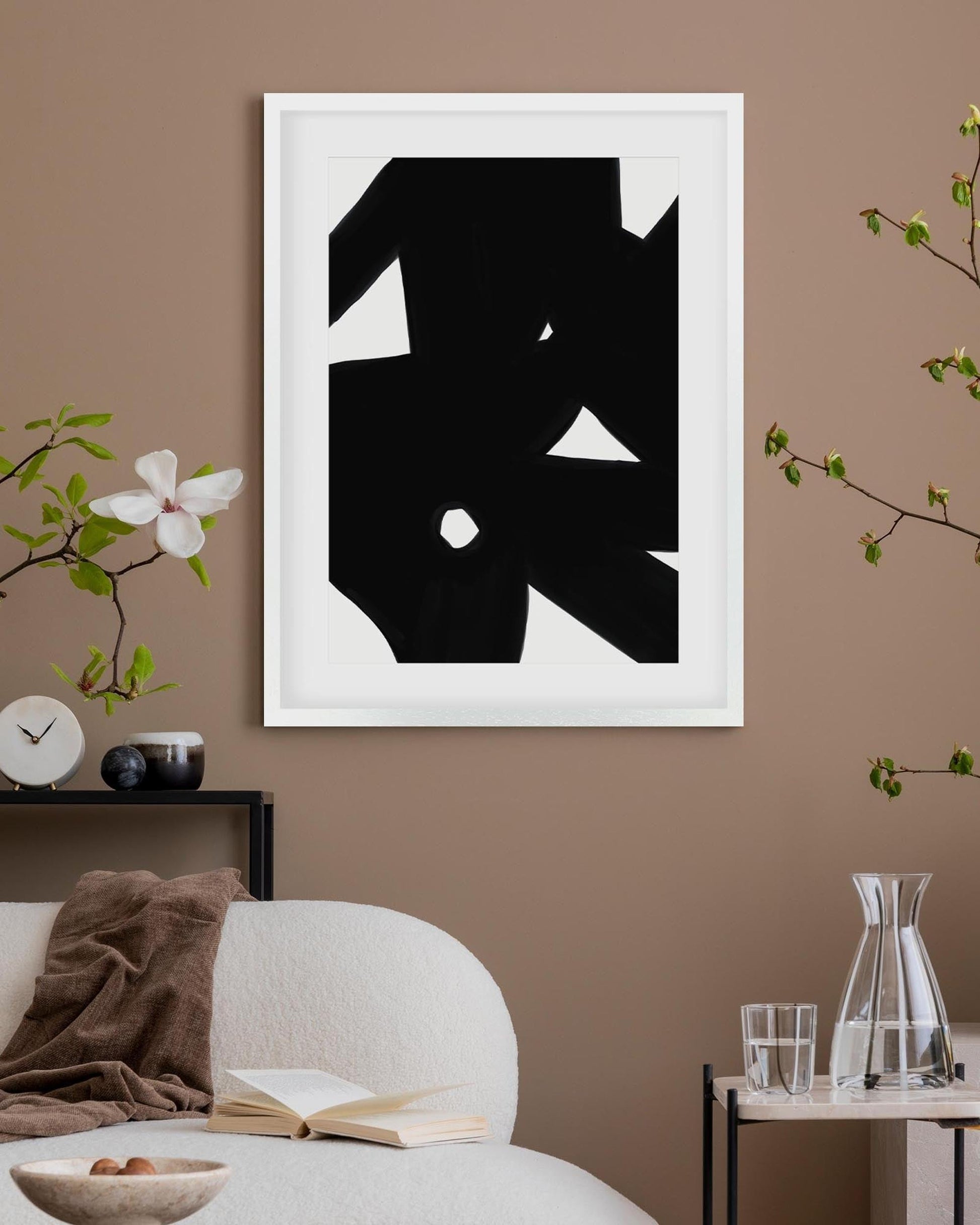 Abstract black and white artwork on a brown wall with decorative elements.