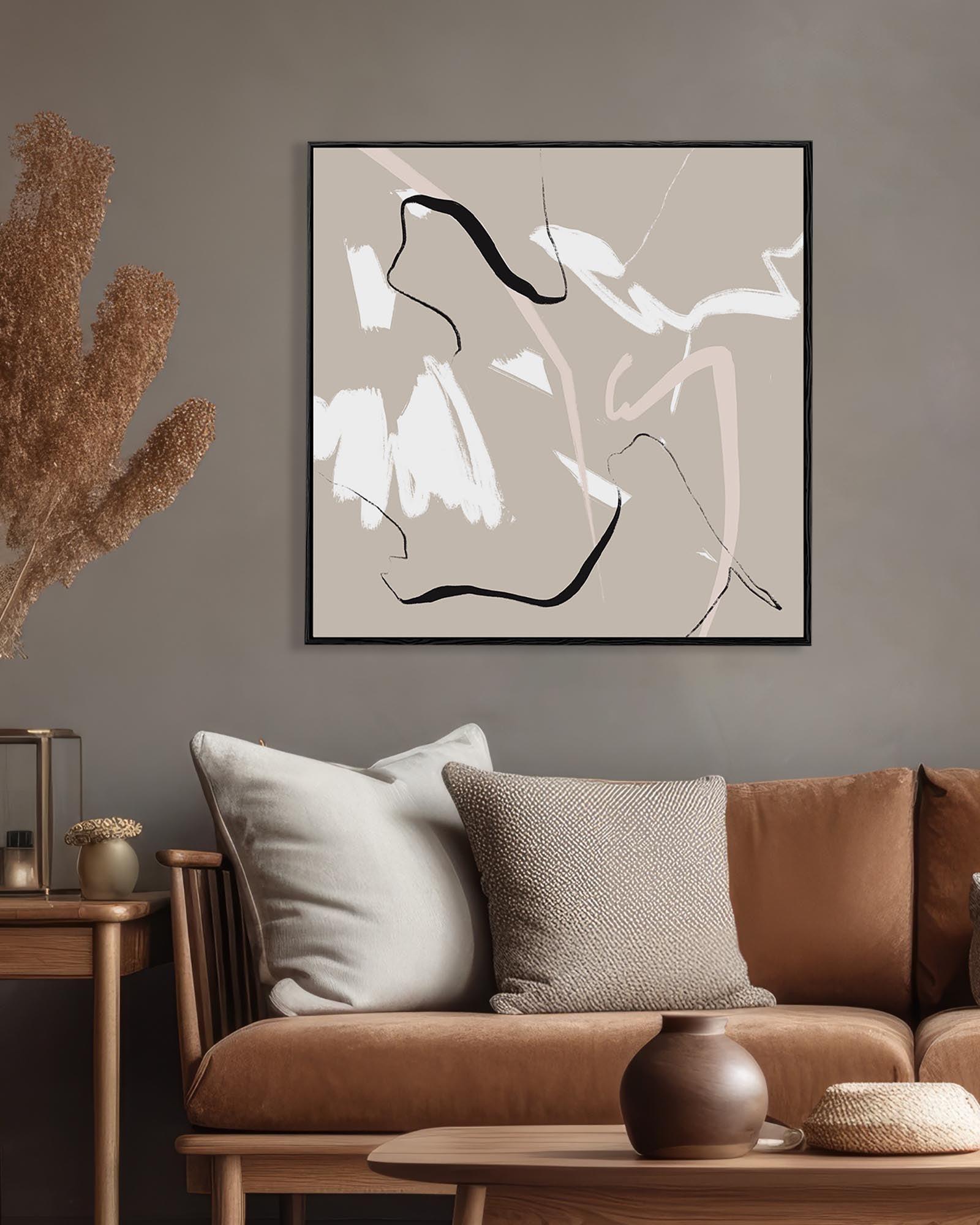 Abstract art piece on a wall above a brown sofa in a living room.