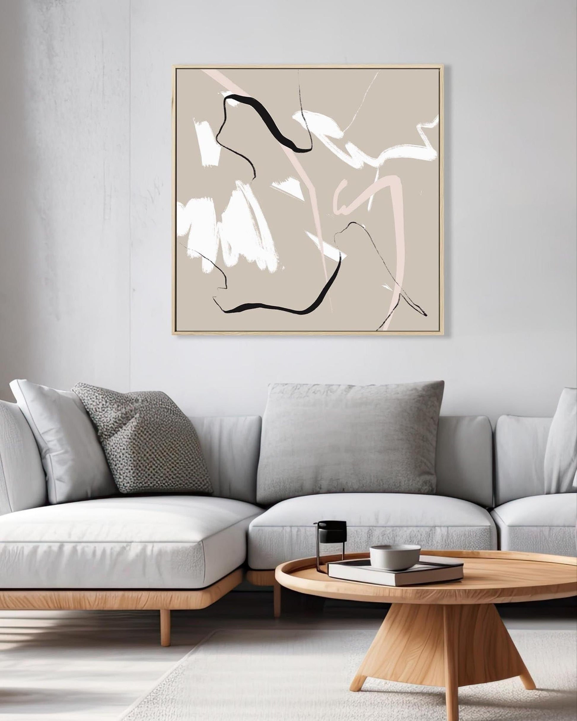 Modern living room with a gray sectional sofa, abstract art, and wooden coffee table.