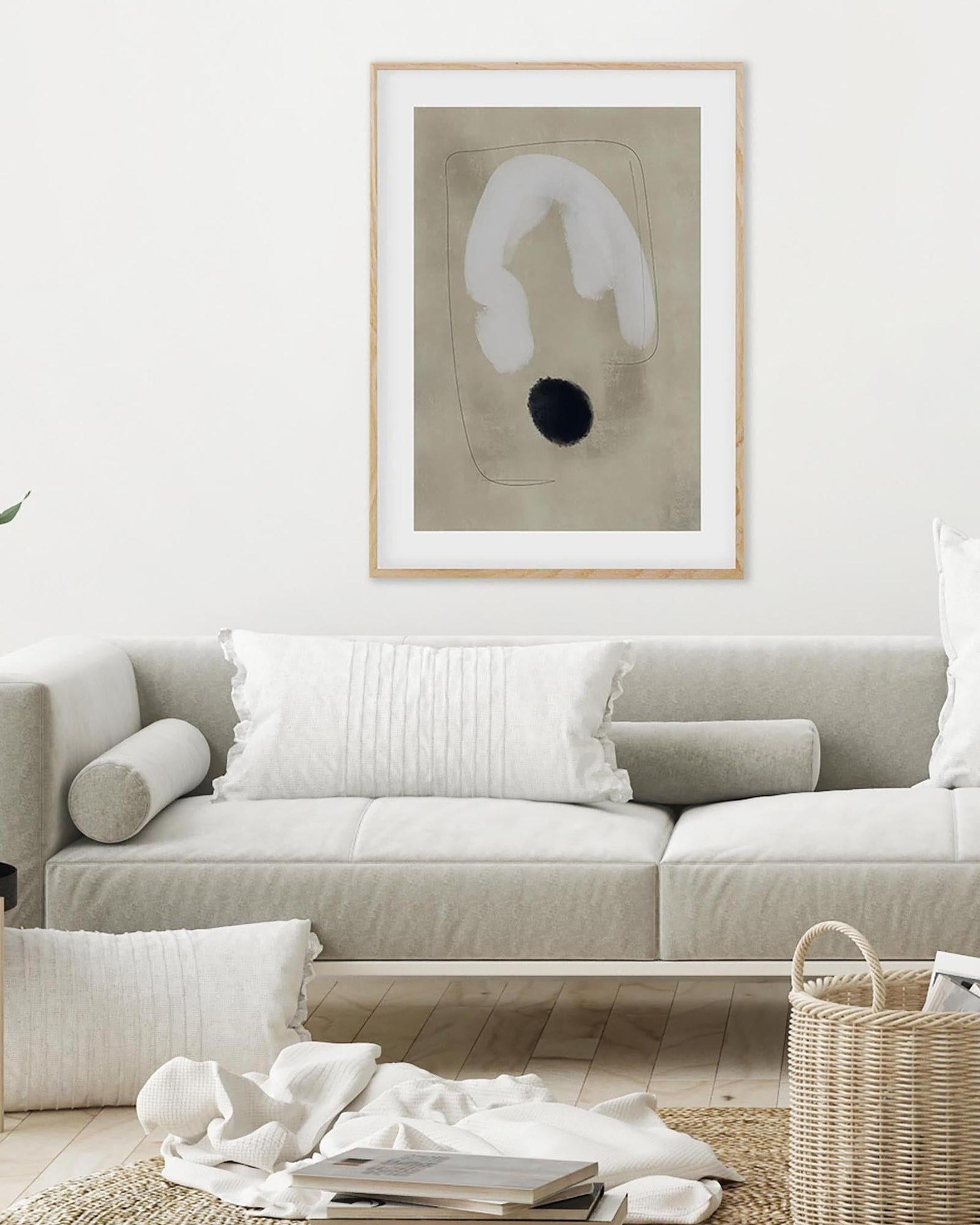 Living room with a beige sofa, abstract art on the wall, and decorative items.