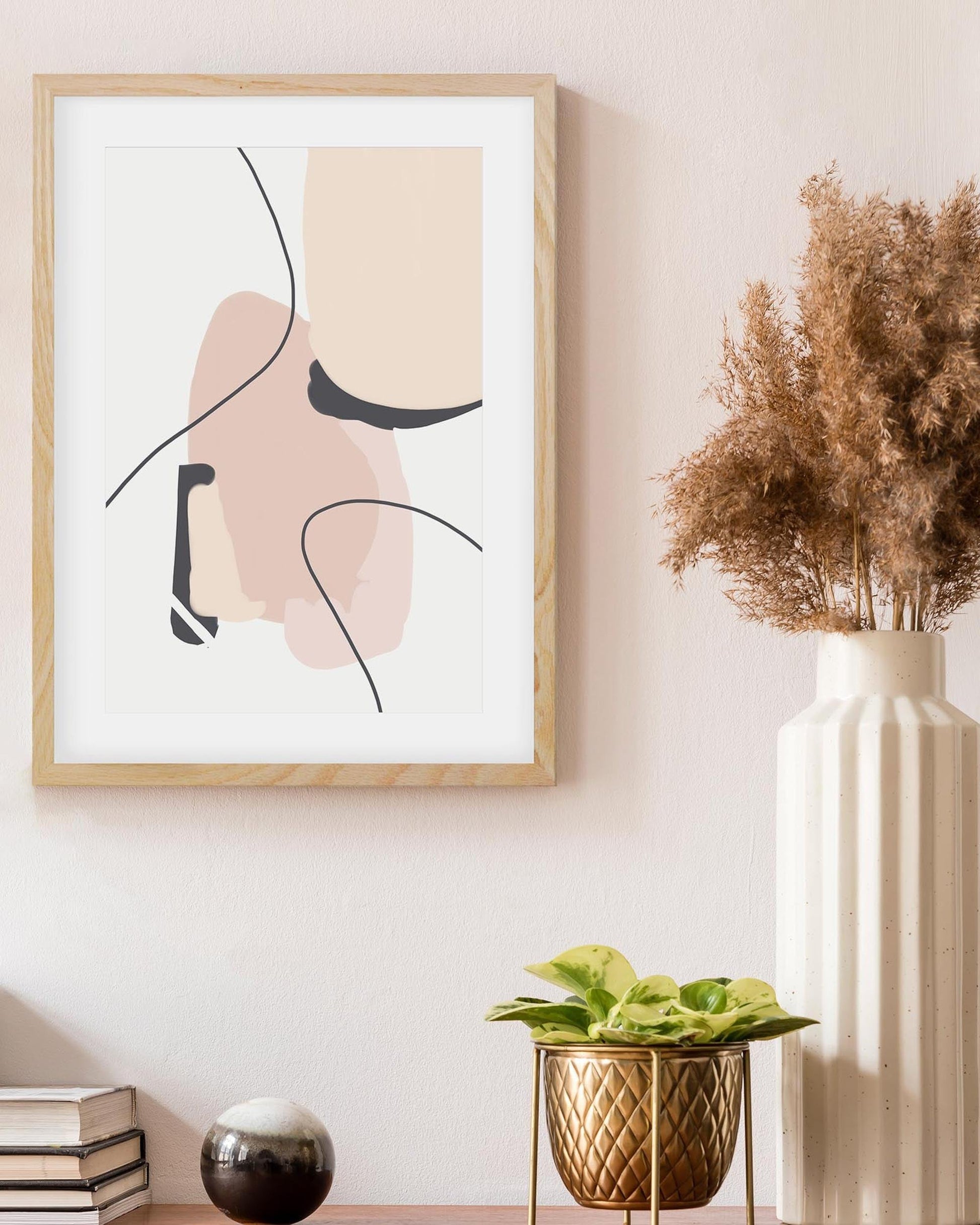 Framed abstract art piece on a wall with decorative elements.