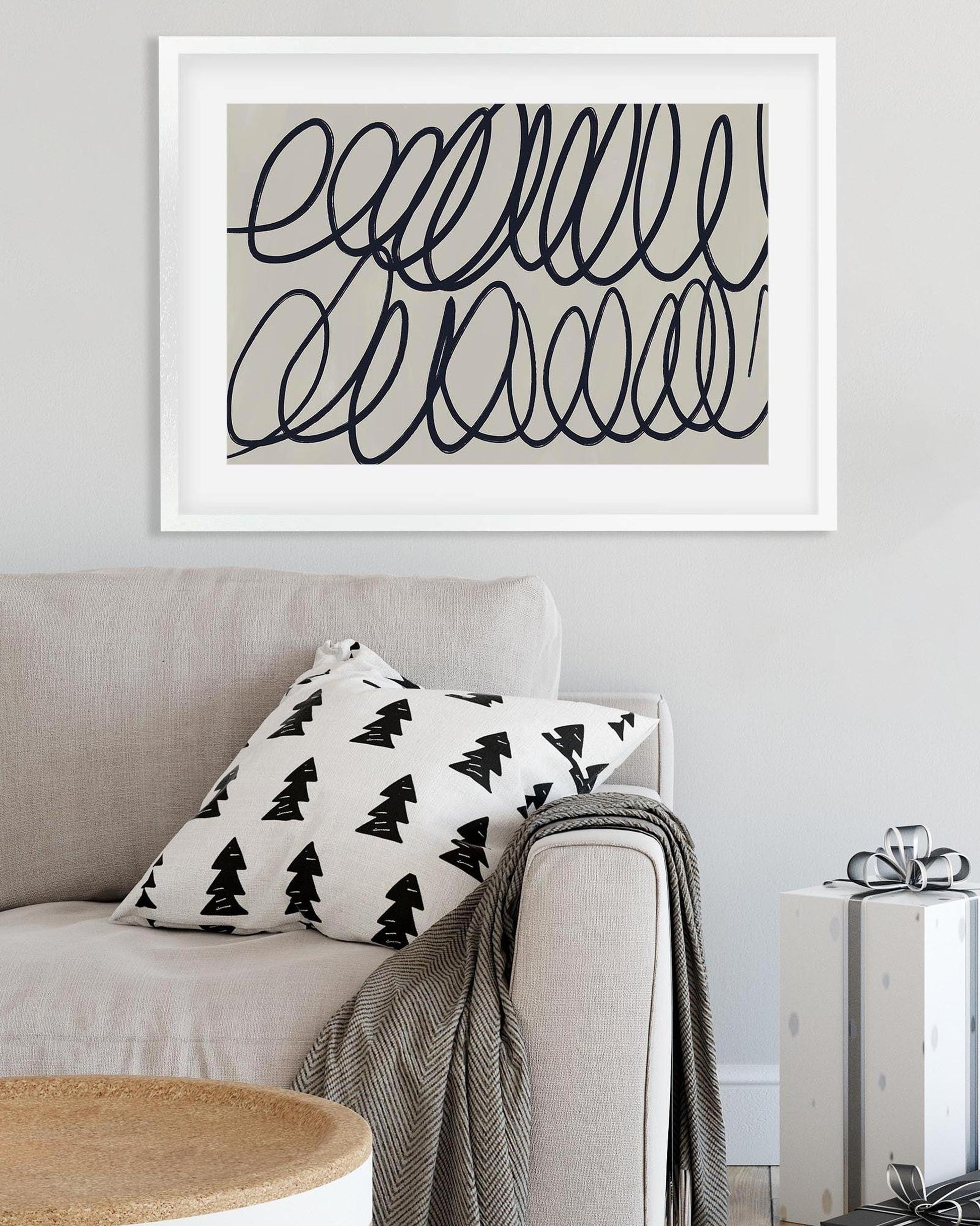 Sofa with decorative pillow and blanket, framed abstract art on wall