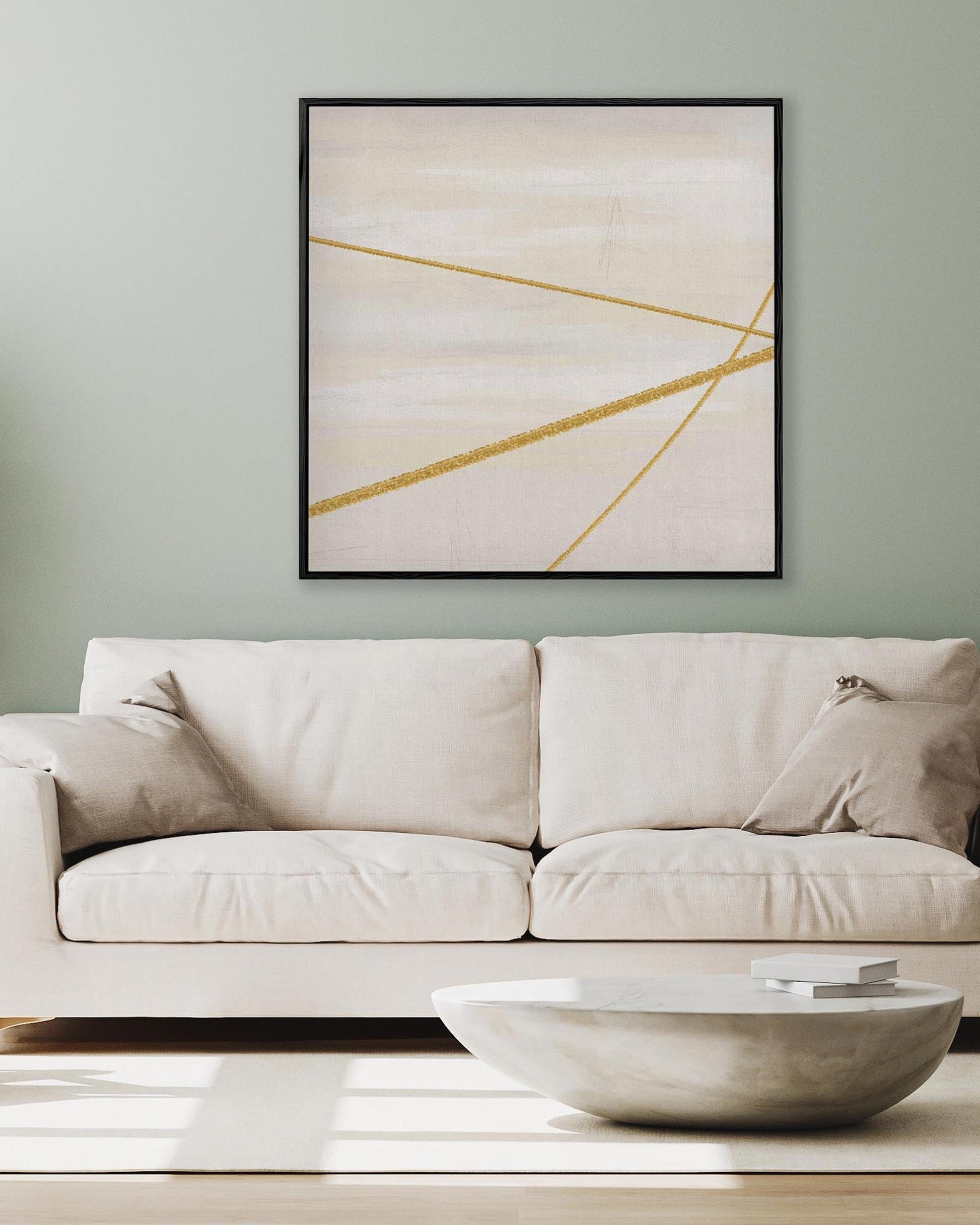 Beige sofa with a modern abstract painting above it on a light green wall.