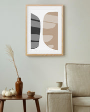 Abstract art print on a wall above a wooden table with decorative items.