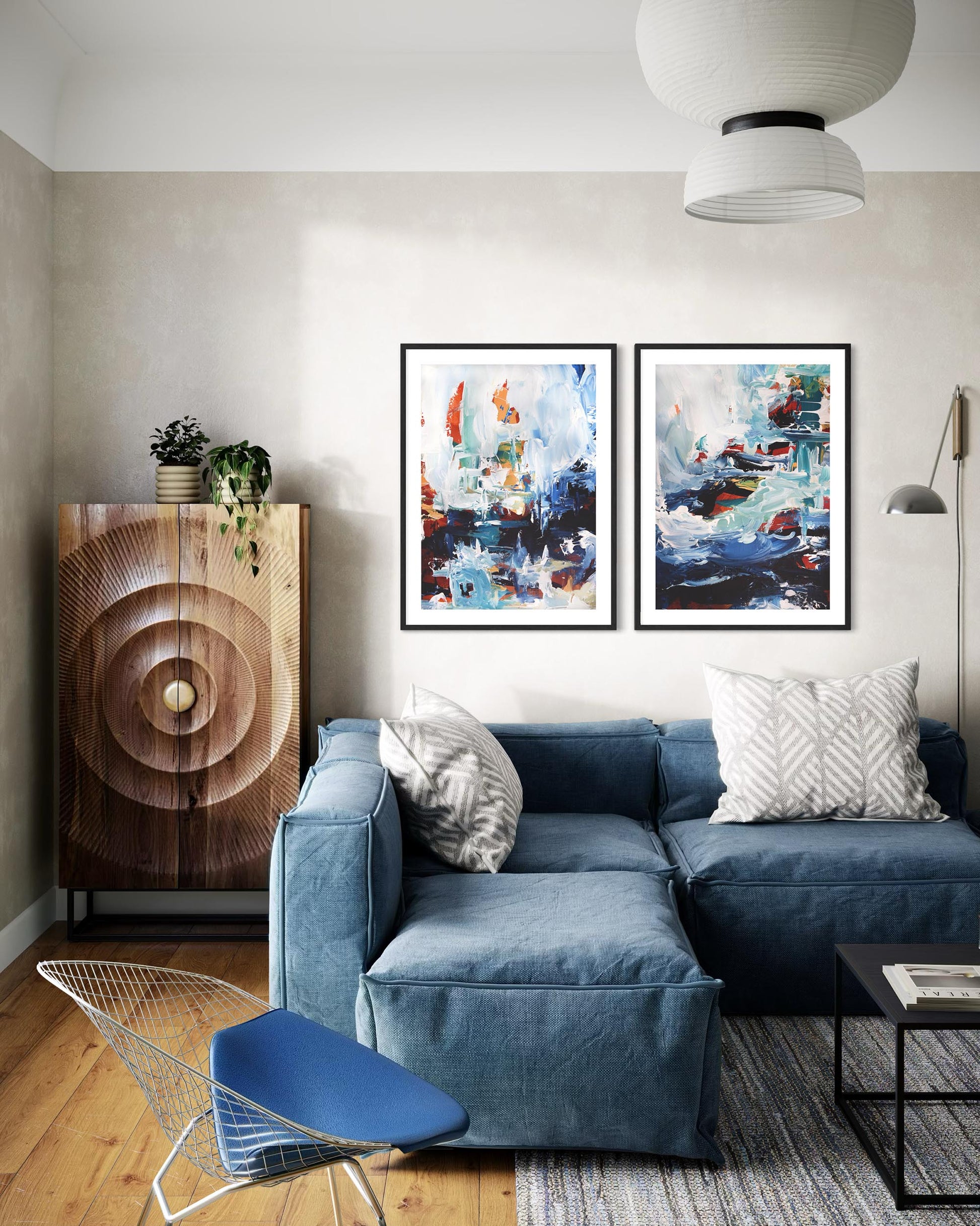 Modern living room with blue sofa, abstract art, and decorative items.