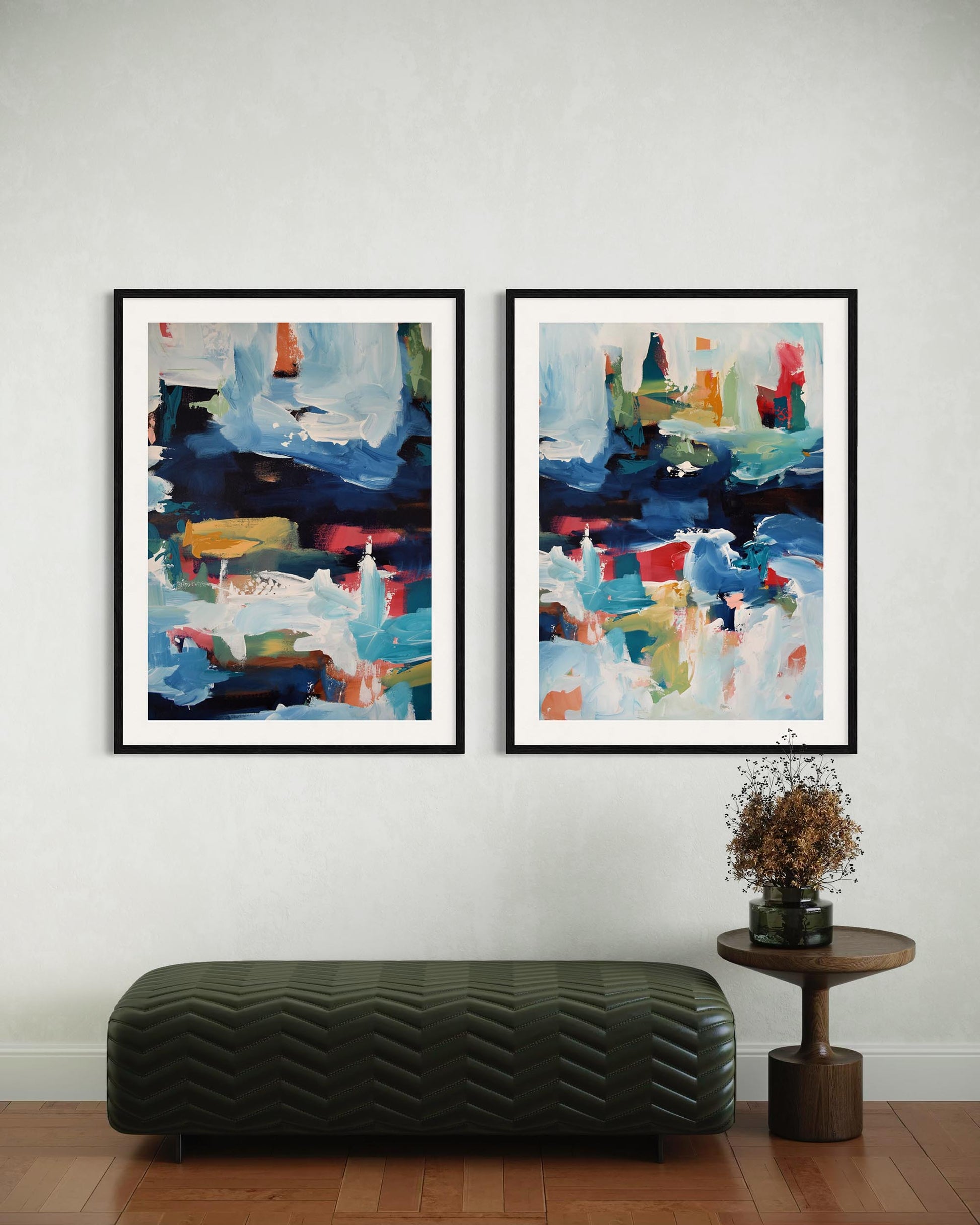 Two abstract paintings on a wall with a bench and small table below.