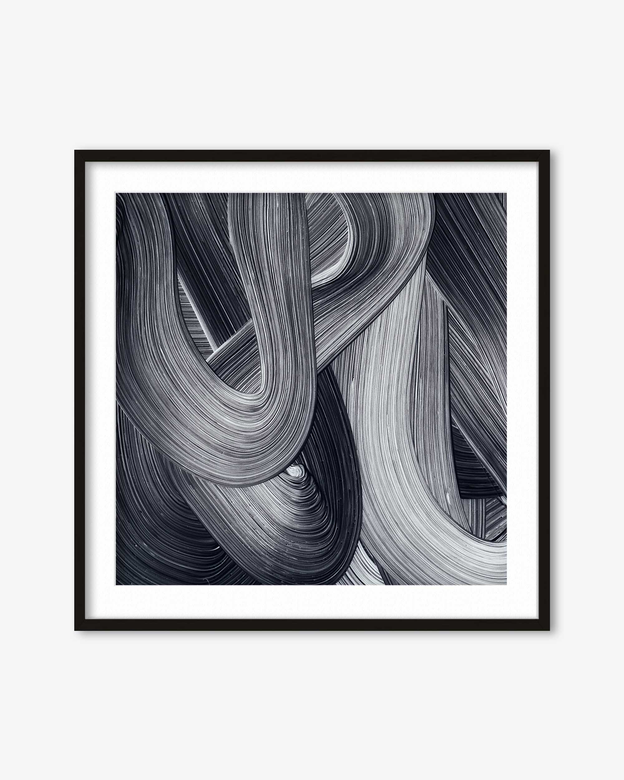 Framed black and white abstract art print on a white wall
