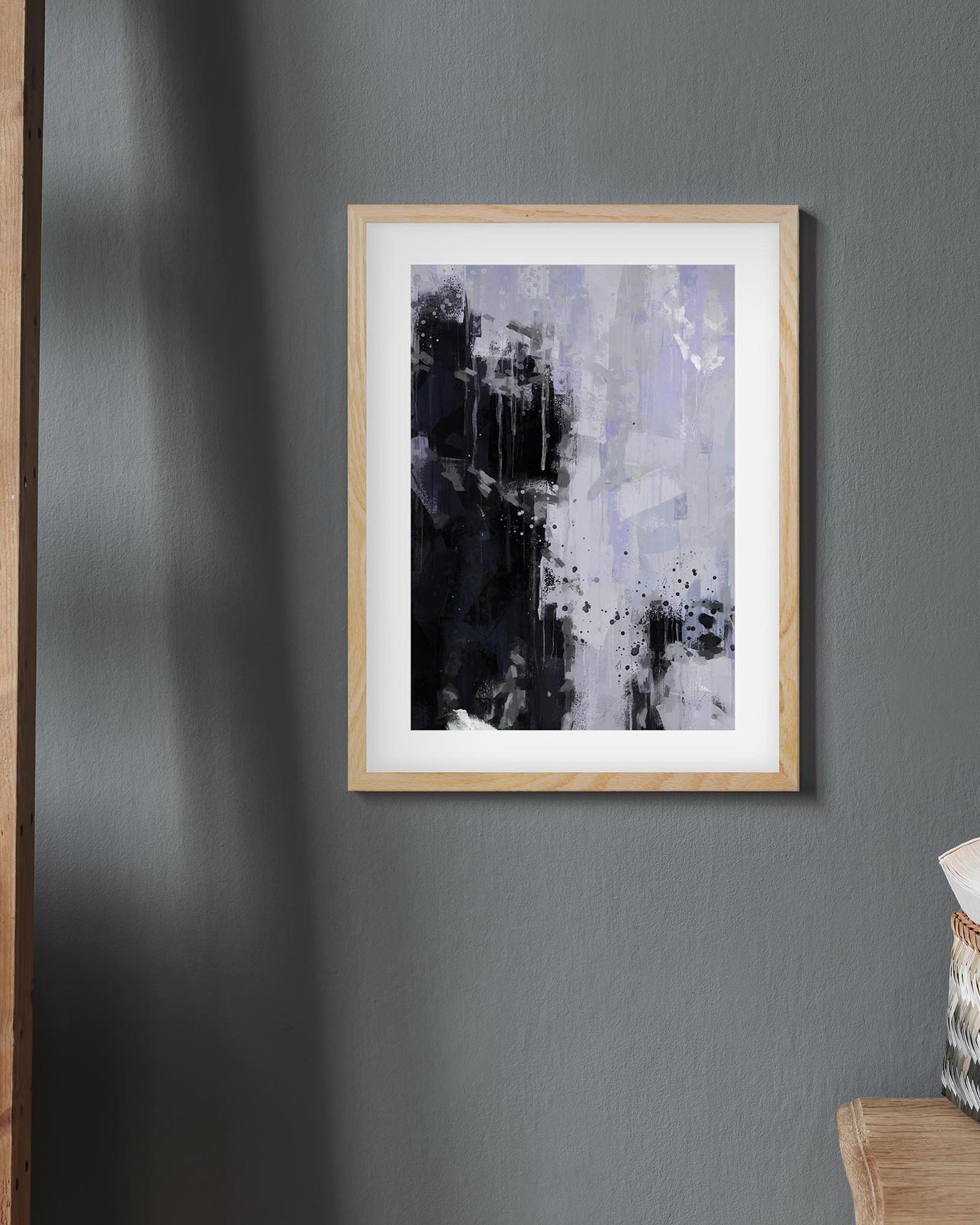 Framed abstract art piece on a gray wall with a chair partially visible.