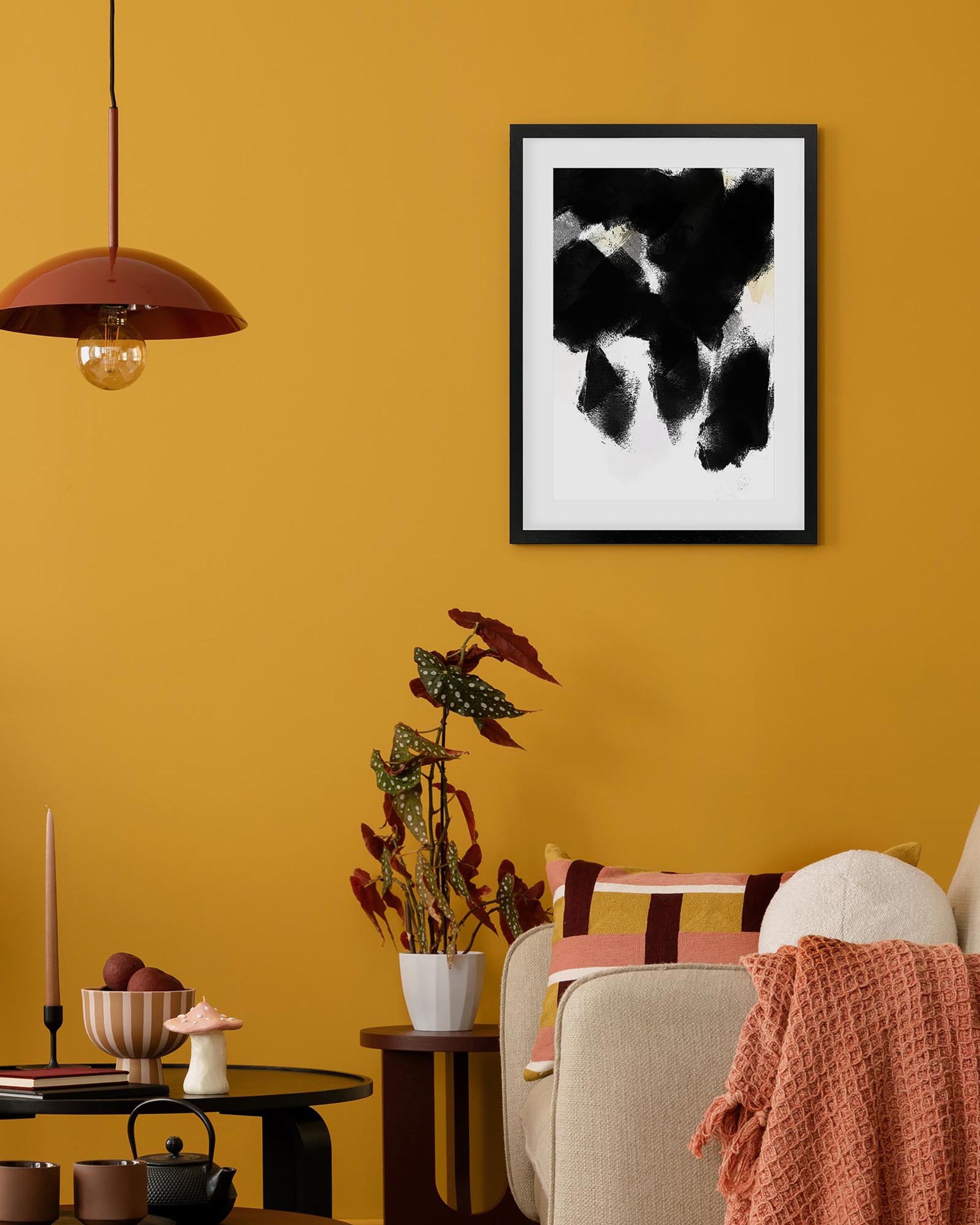 Living room with yellow walls, a framed abstract painting, and decorative items.