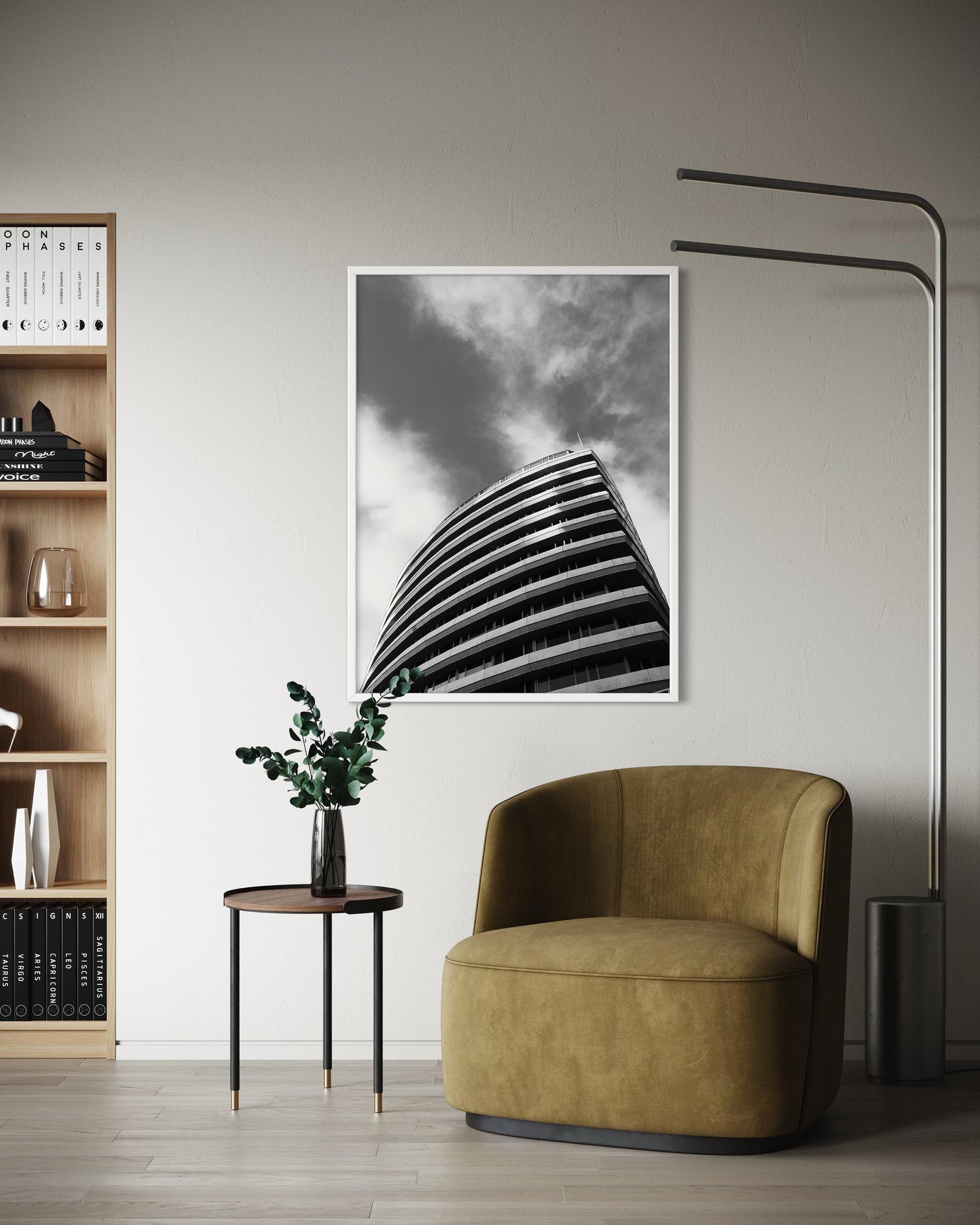 Modern interior with a brown armchair, bookshelf, and abstract art on the wall.