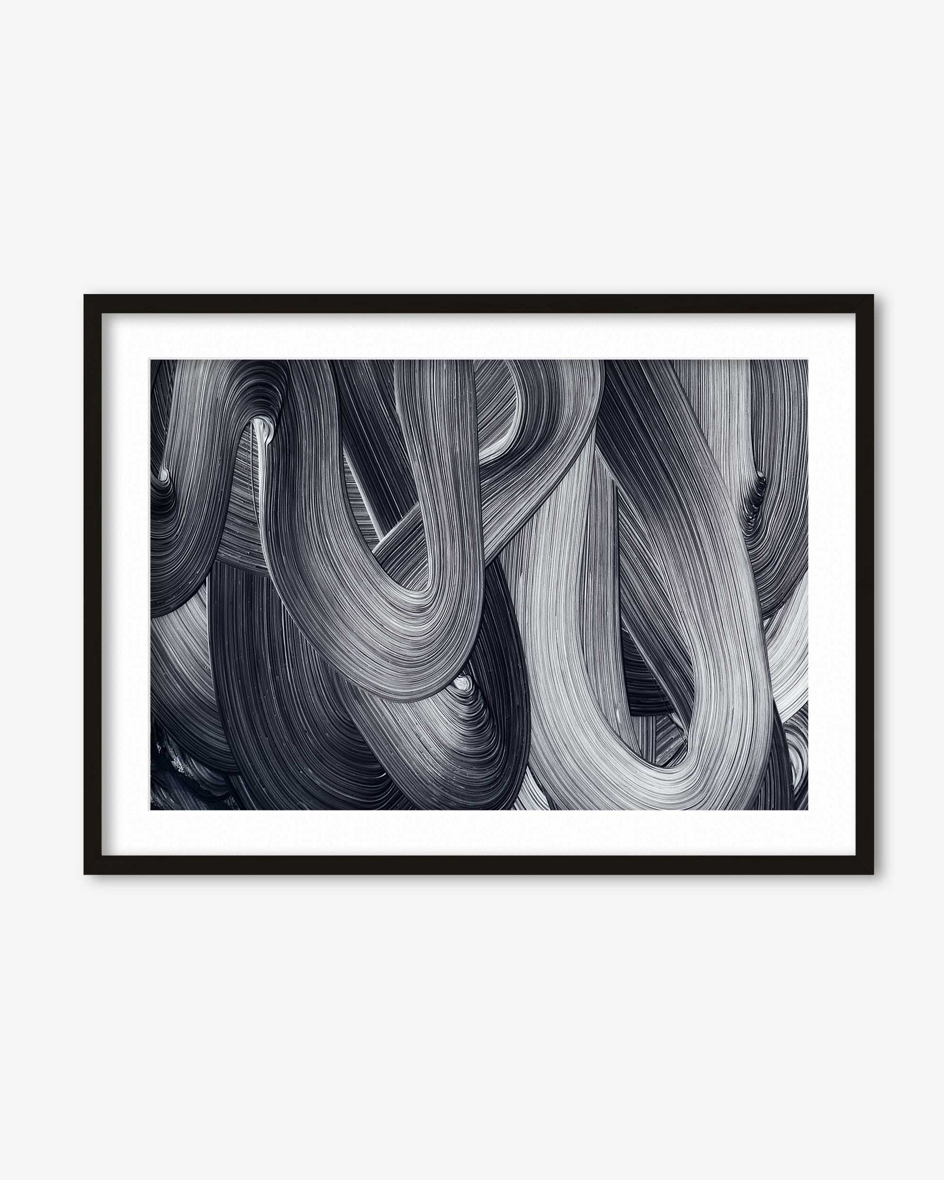 Framed black and white abstract art print on a white wall
