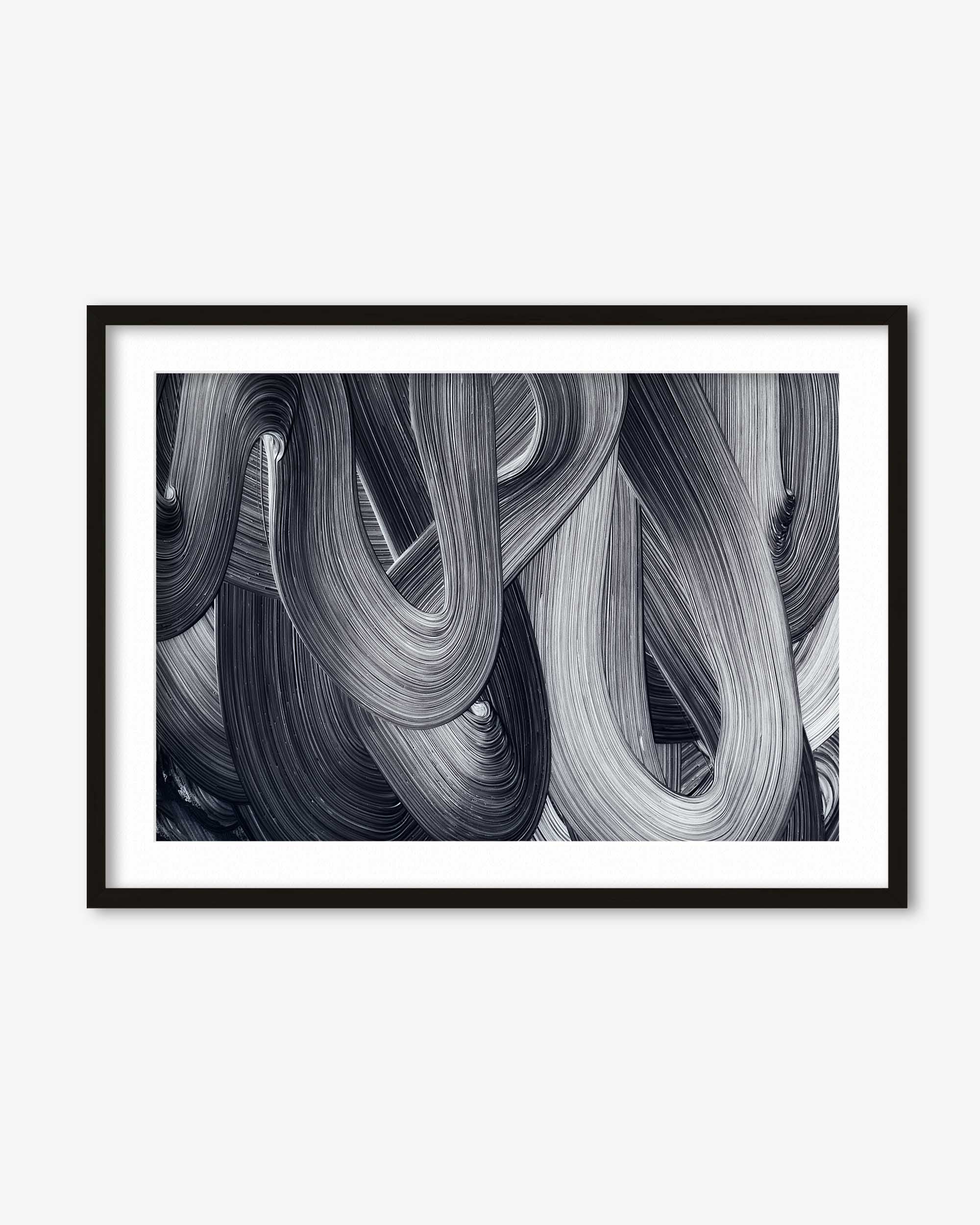 Framed black and white abstract art print on a white wall