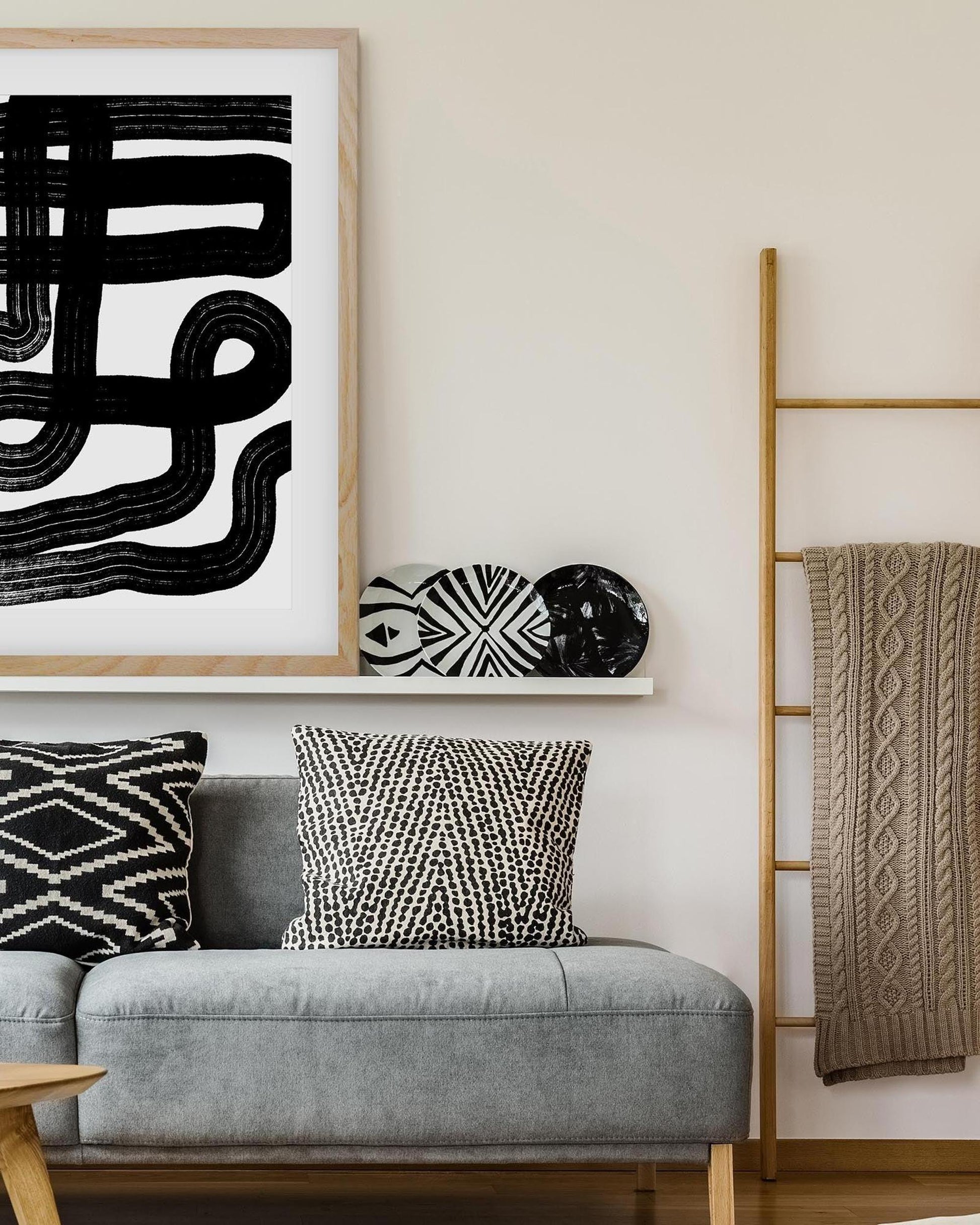Living room with gray sofa, decorative pillows, and a wall art piece.