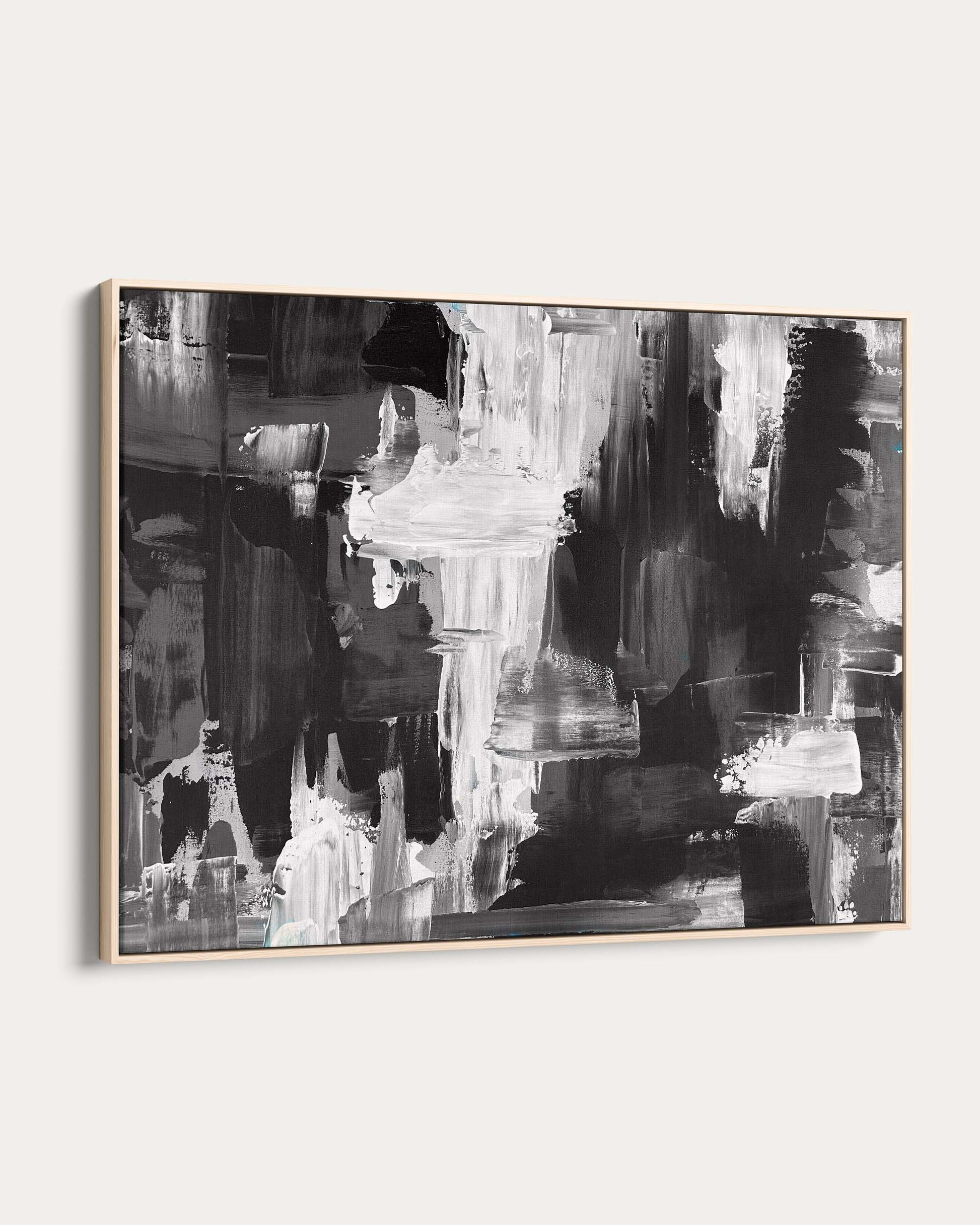 Abstract black and white painting in a gold frame on a white wall