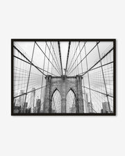 Framed black and white photo of the Brooklyn Bridge on a white wall