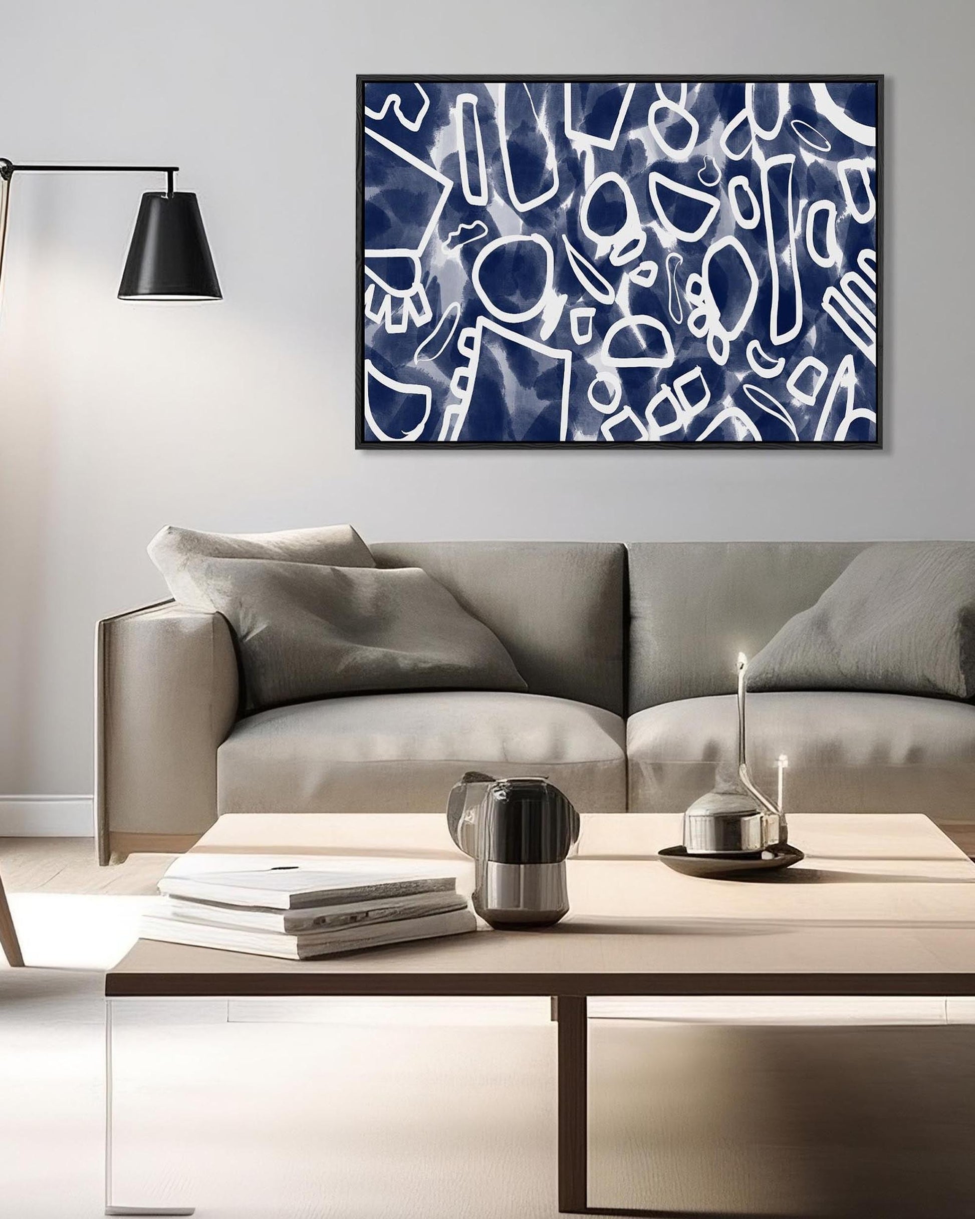 Modern living room with a gray sofa, coffee table, and abstract art on the wall.