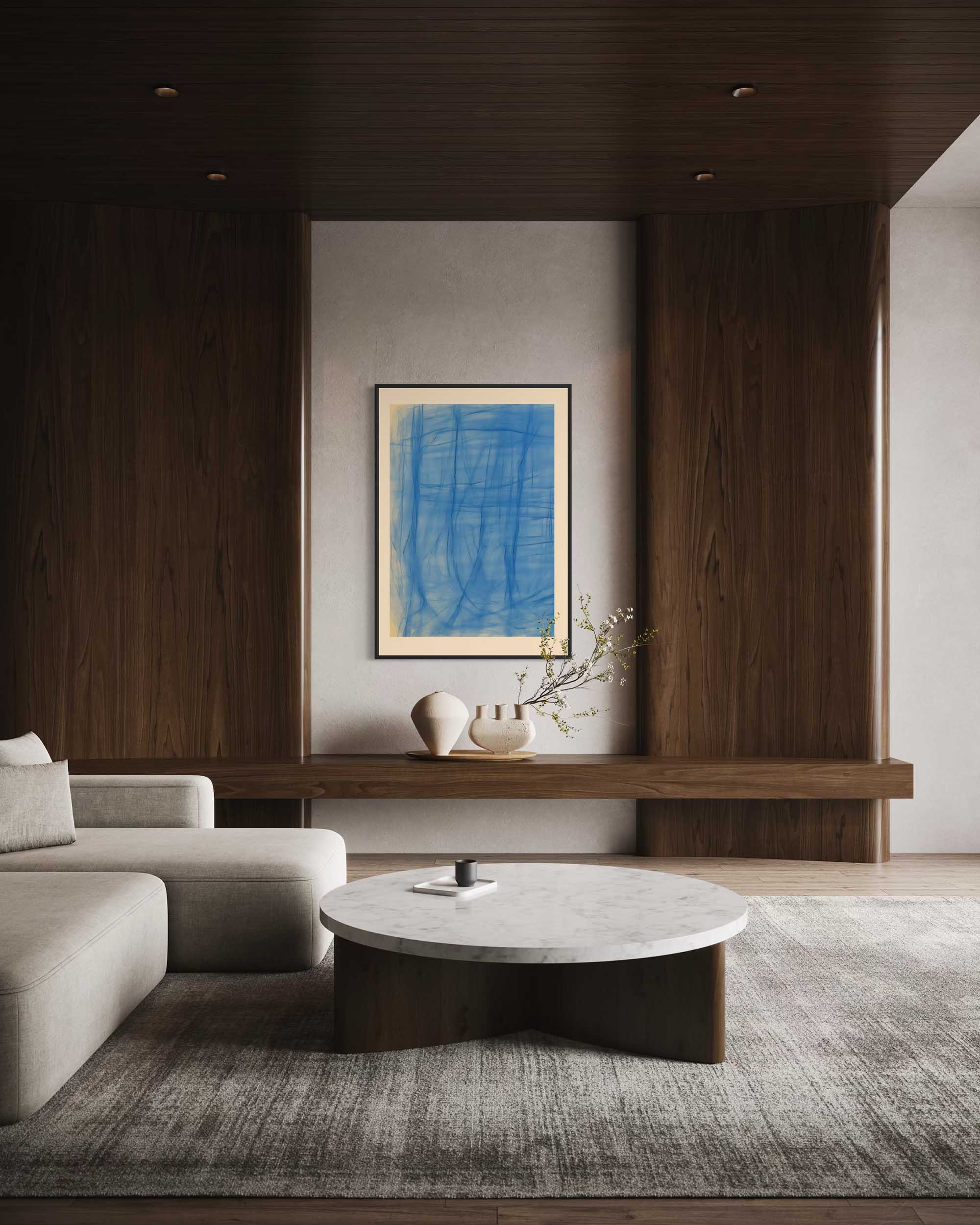 Modern living room with a gray sofa, round marble coffee table, and abstract blue painting.