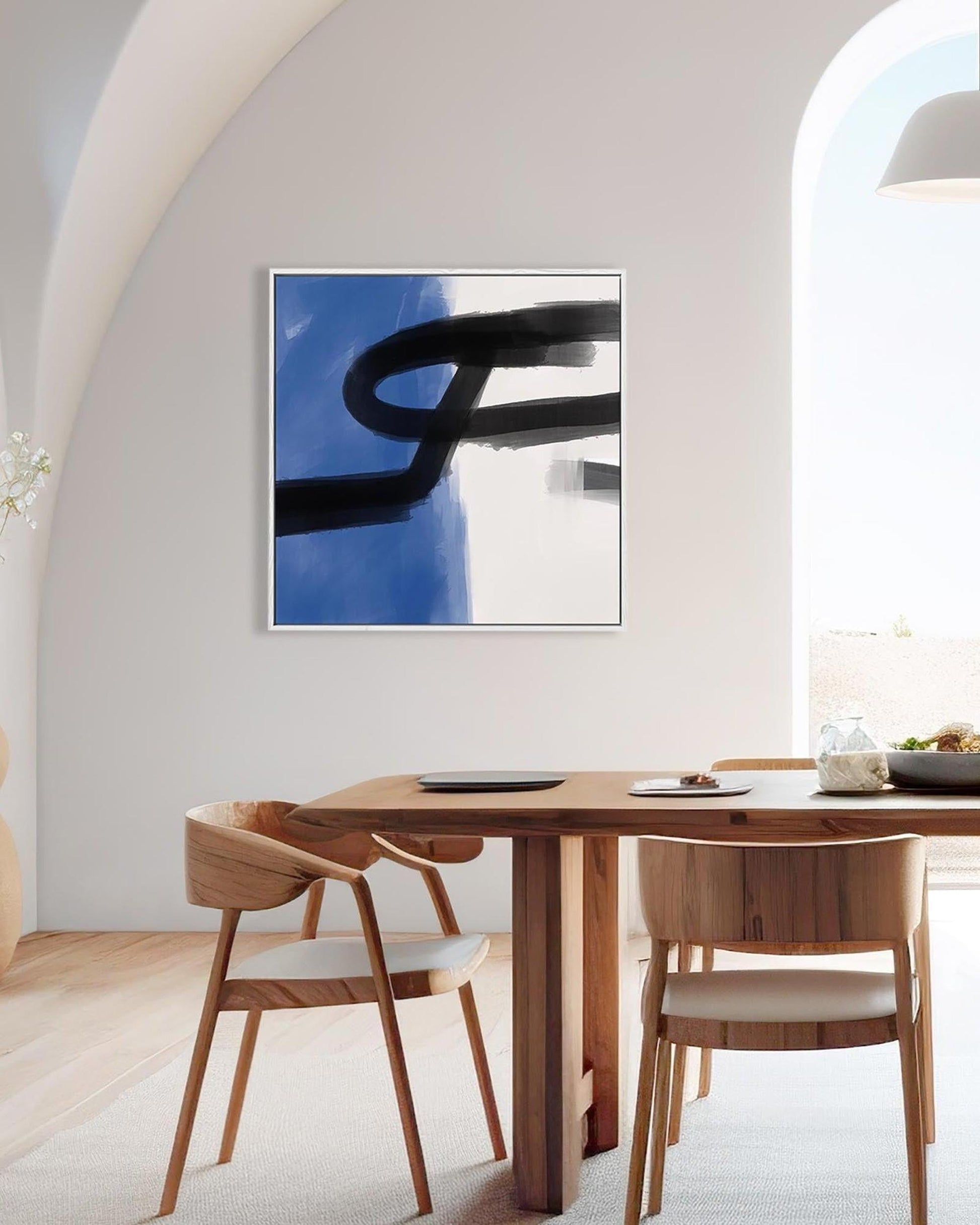 Modern dining room with wooden table and chairs, abstract art on the wall.