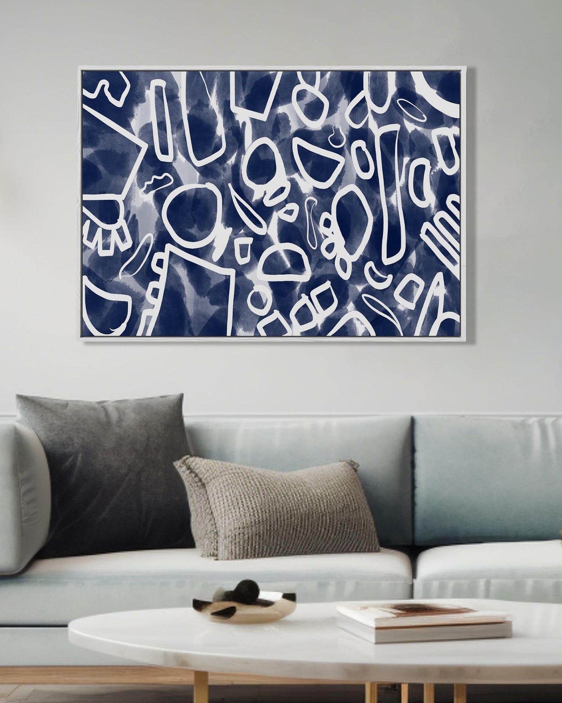Abstract art piece on a wall above a sofa in a living room