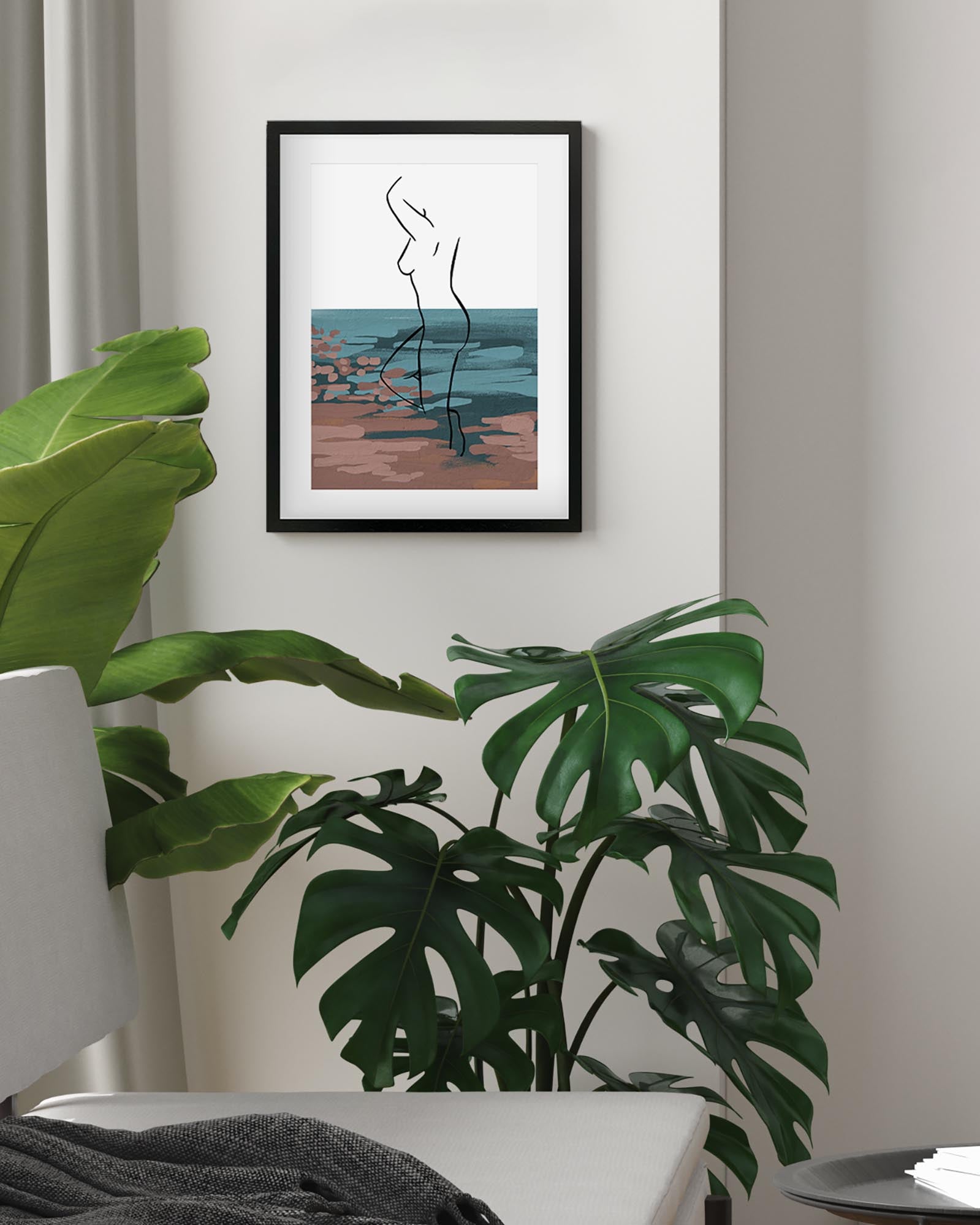 Framed abstract artwork on a wall with plants in the foreground