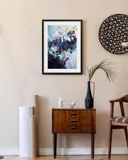 Modern living room with abstract art, wooden cabinet, and decorative items.