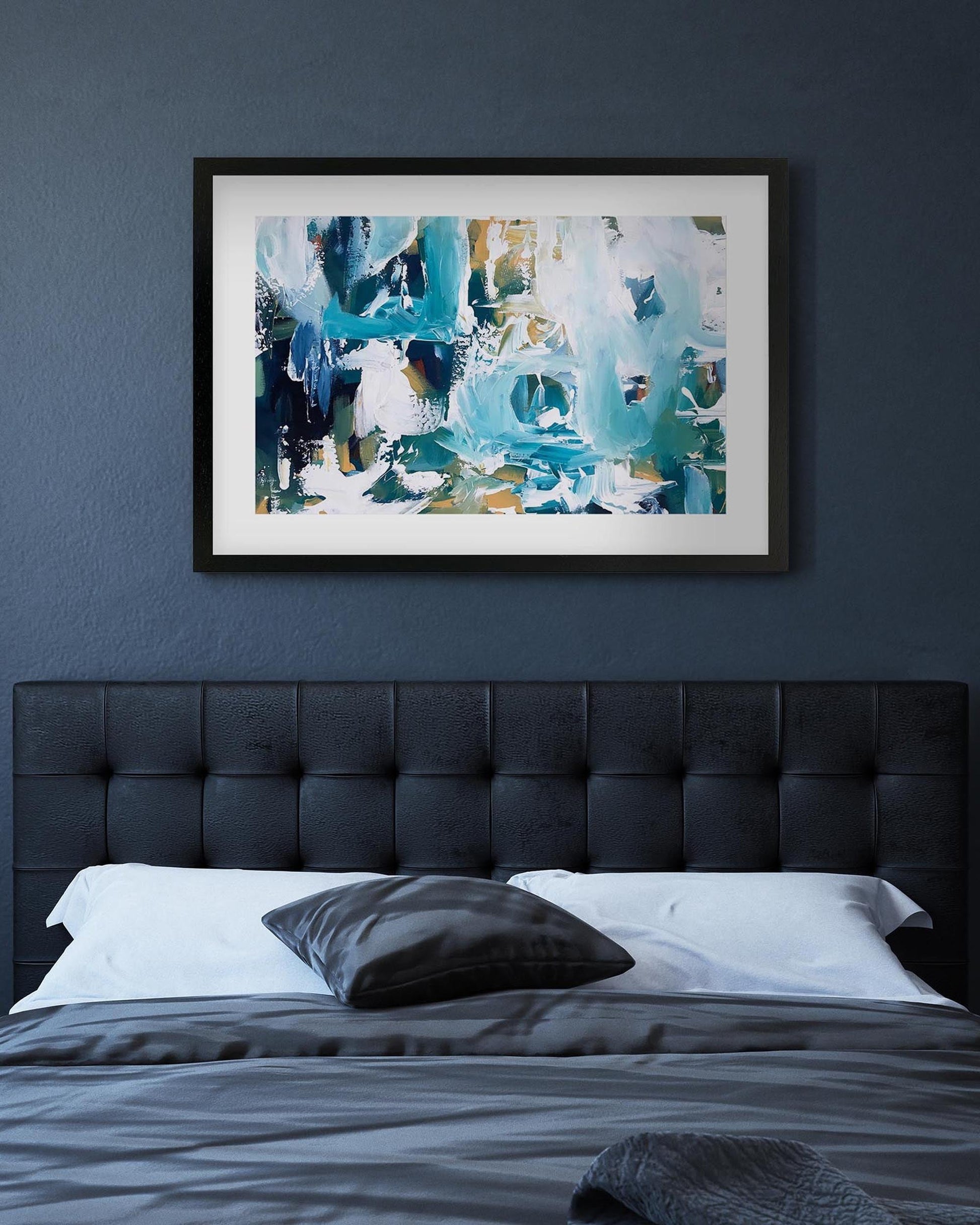 Abstract painting on a dark blue wall above a bed with a tufted headboard.