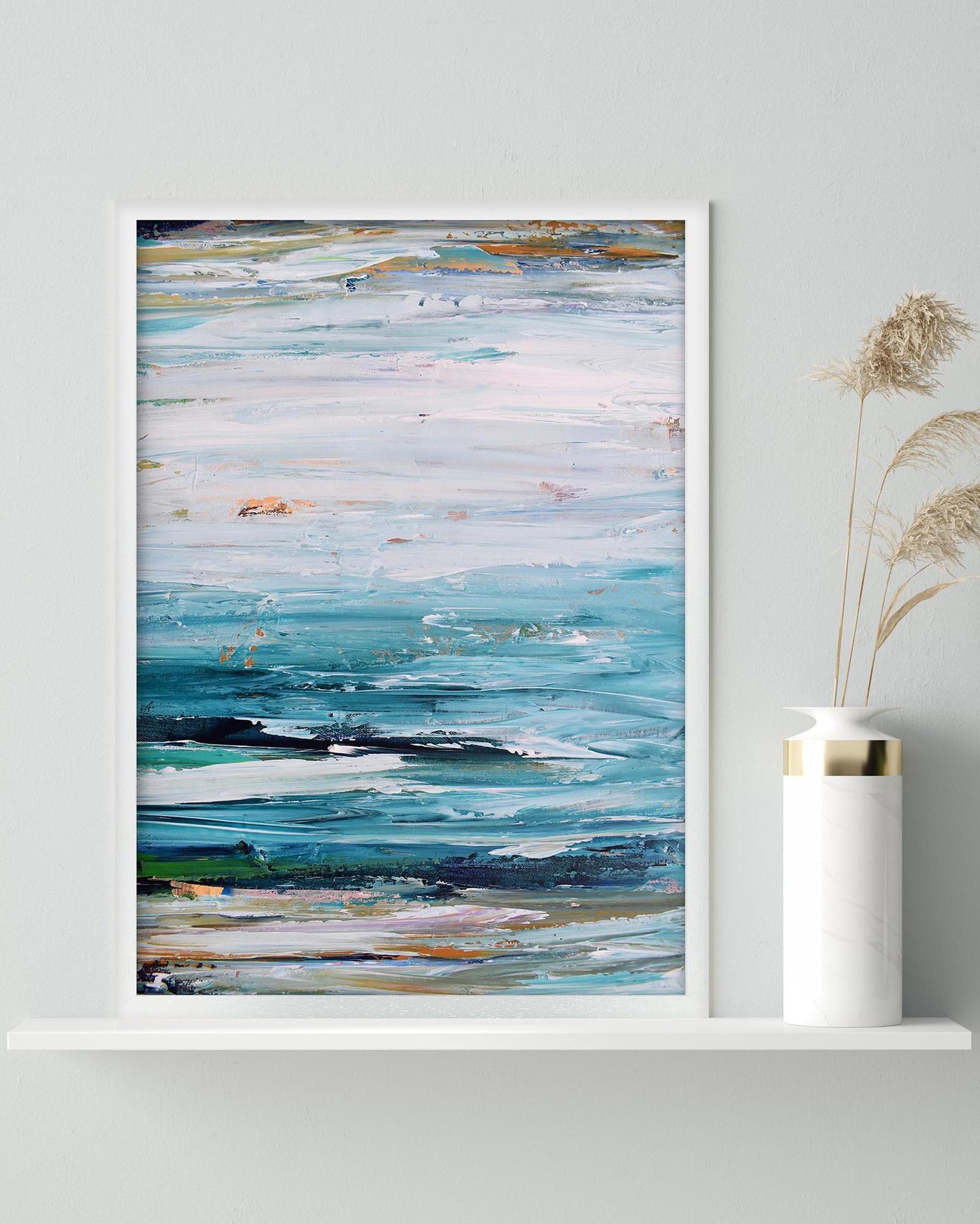 Abstract painting on a wall with a vase containing dried plants below.