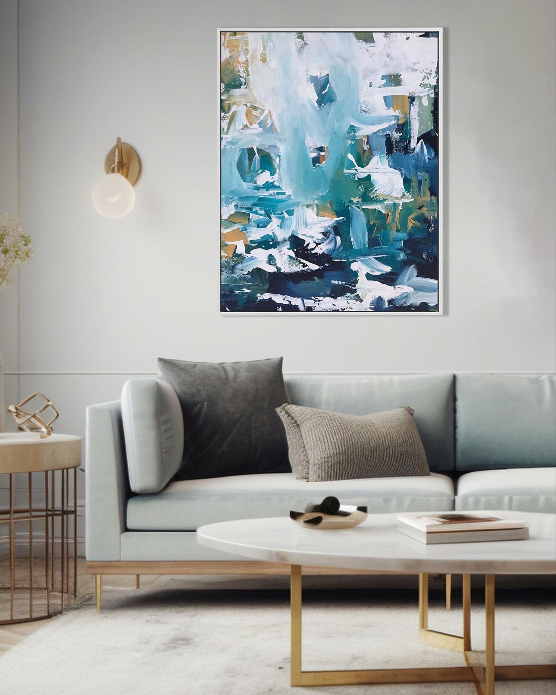 Modern living room with a gray sofa, abstract painting, and side table.