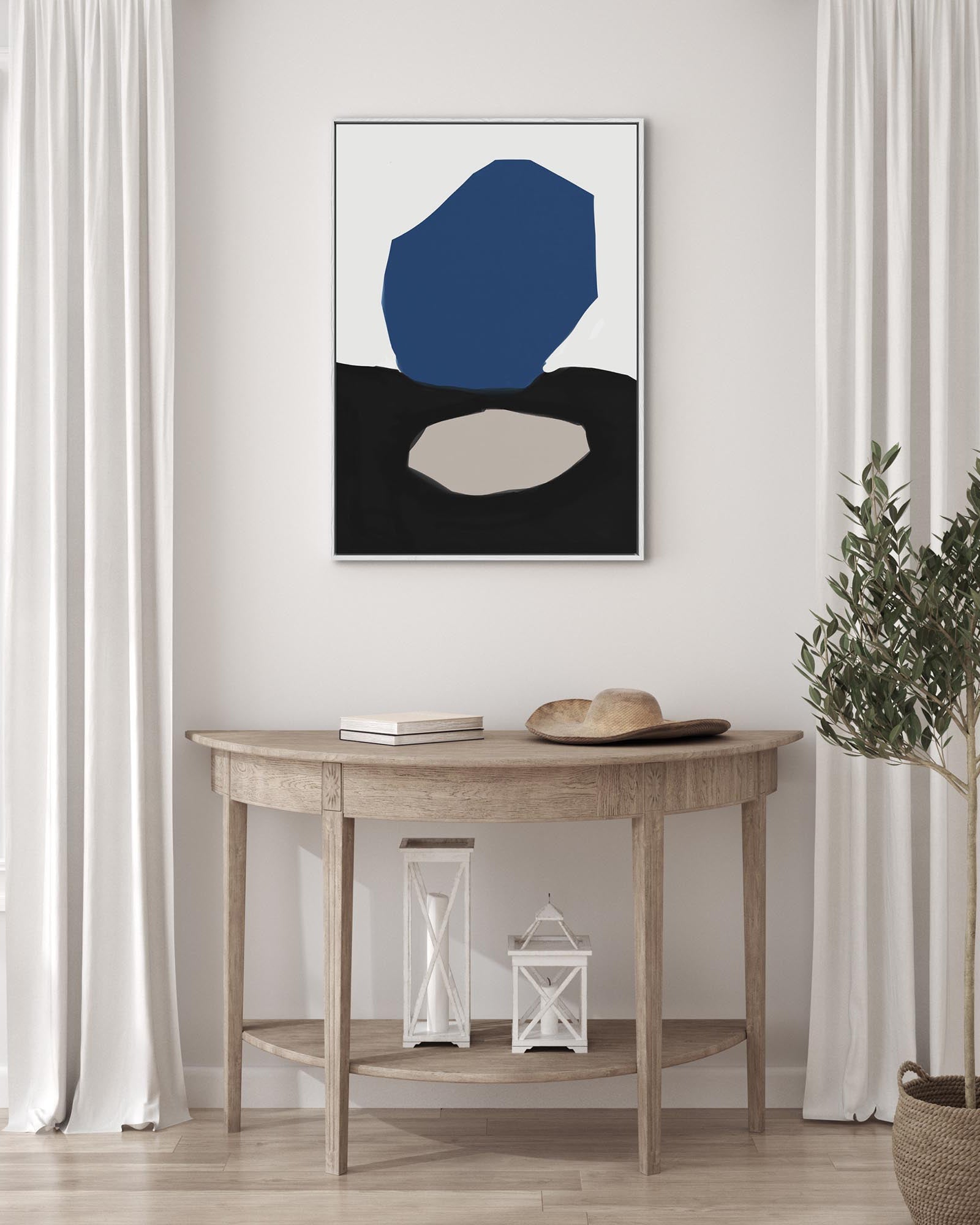 Abstract art piece with a blue shape on a wall above a wooden table.