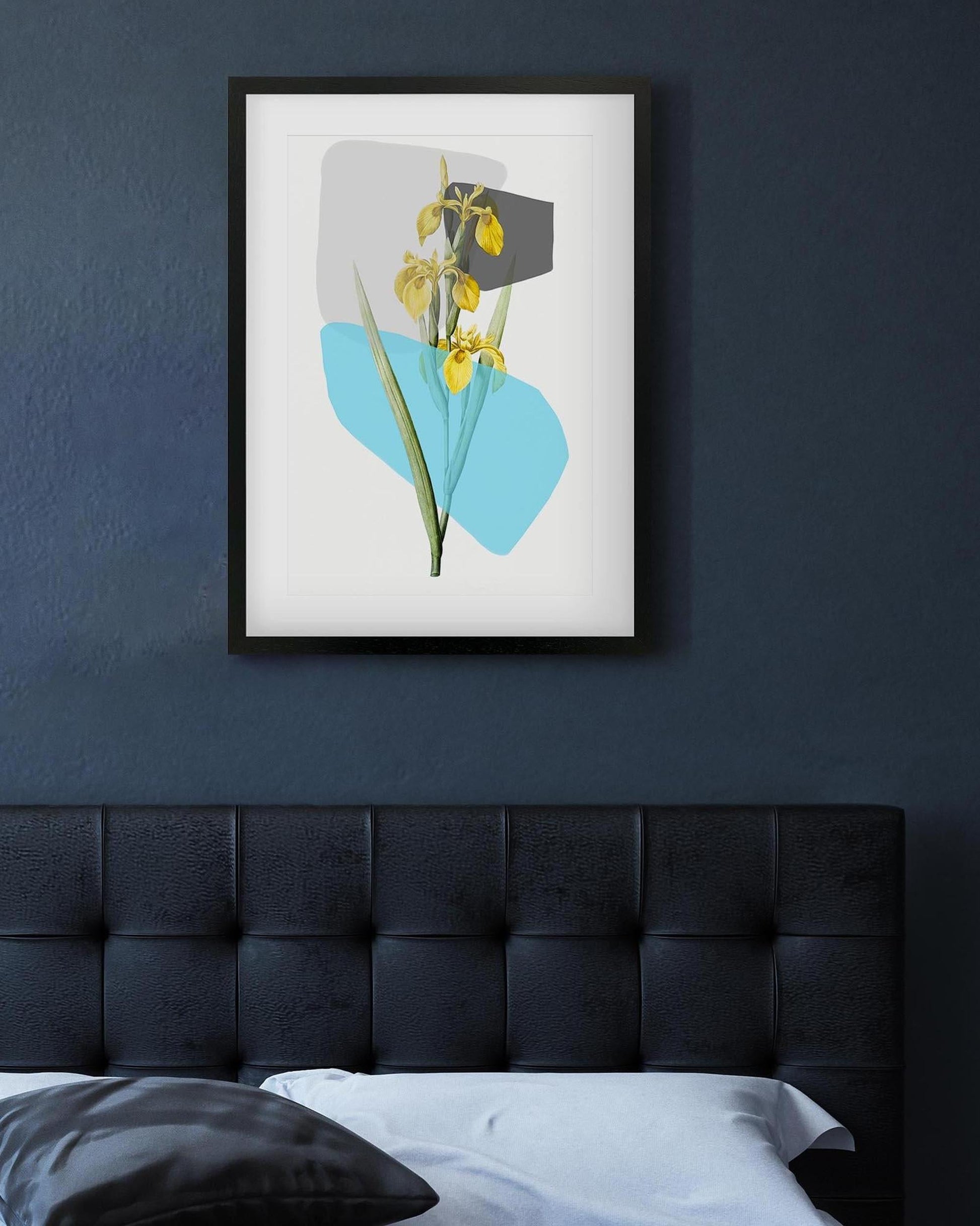 Framed artwork with floral design on a dark blue wall above a bed.