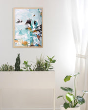 Abstract art print on a wall with plants below