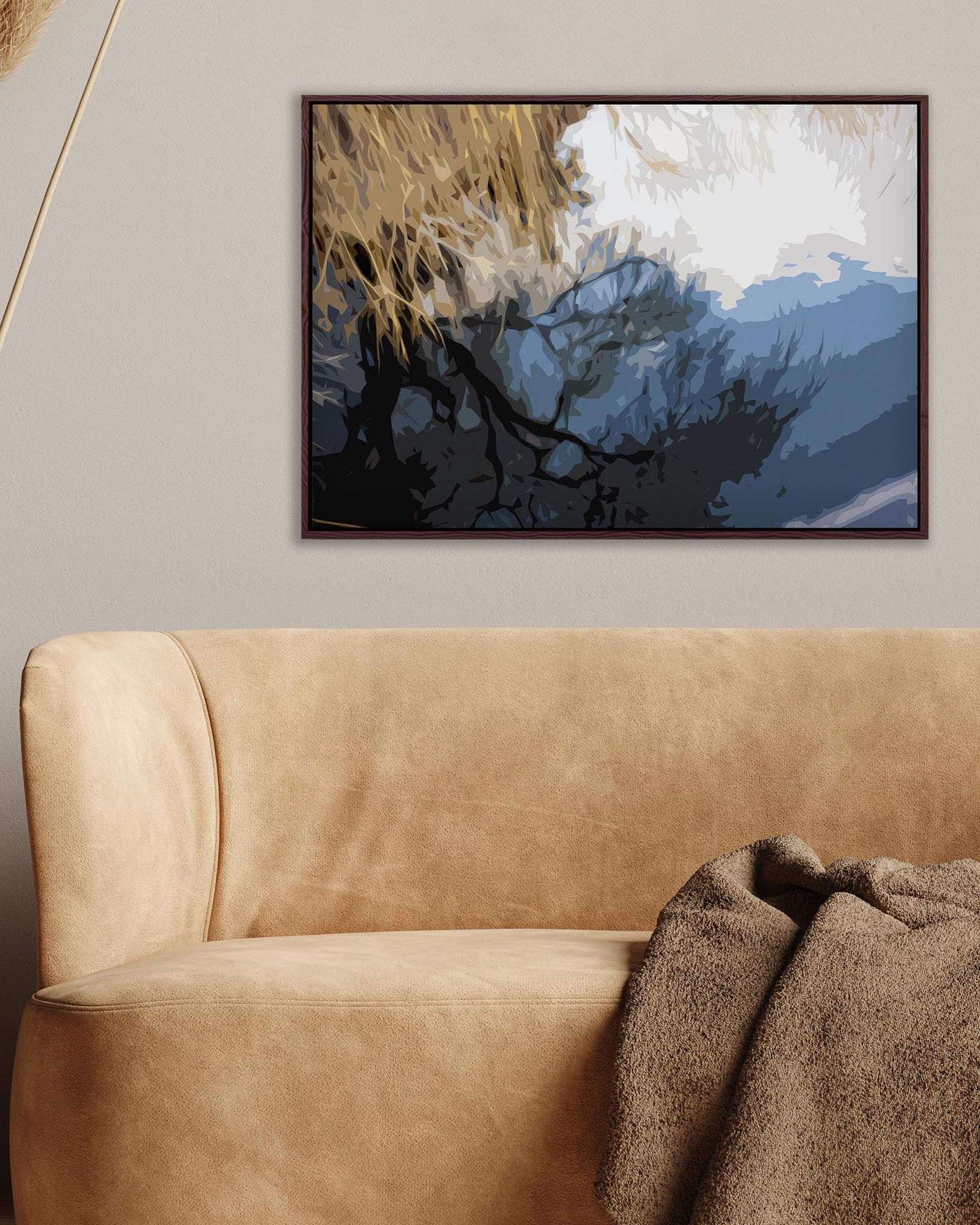 Abstract painting above a beige sofa with a brown blanket