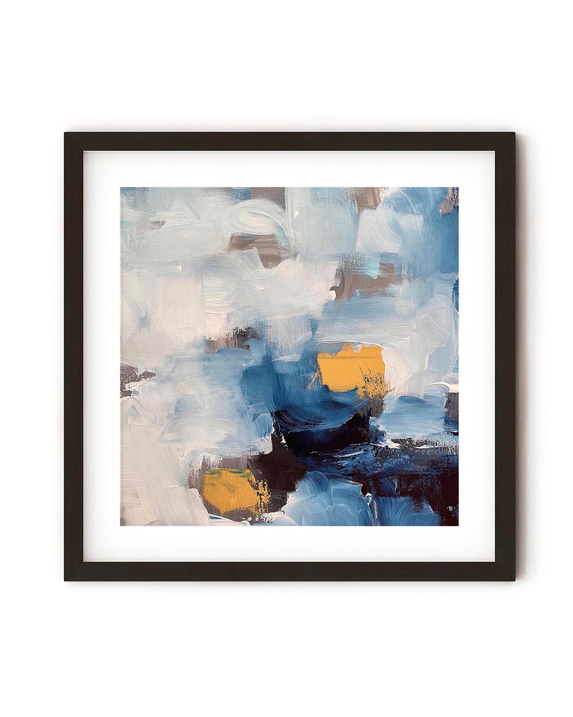 A framed art print featuring abstract blue ocean waves with gray, white, and yellow ochre brushstrokes on a black frame.