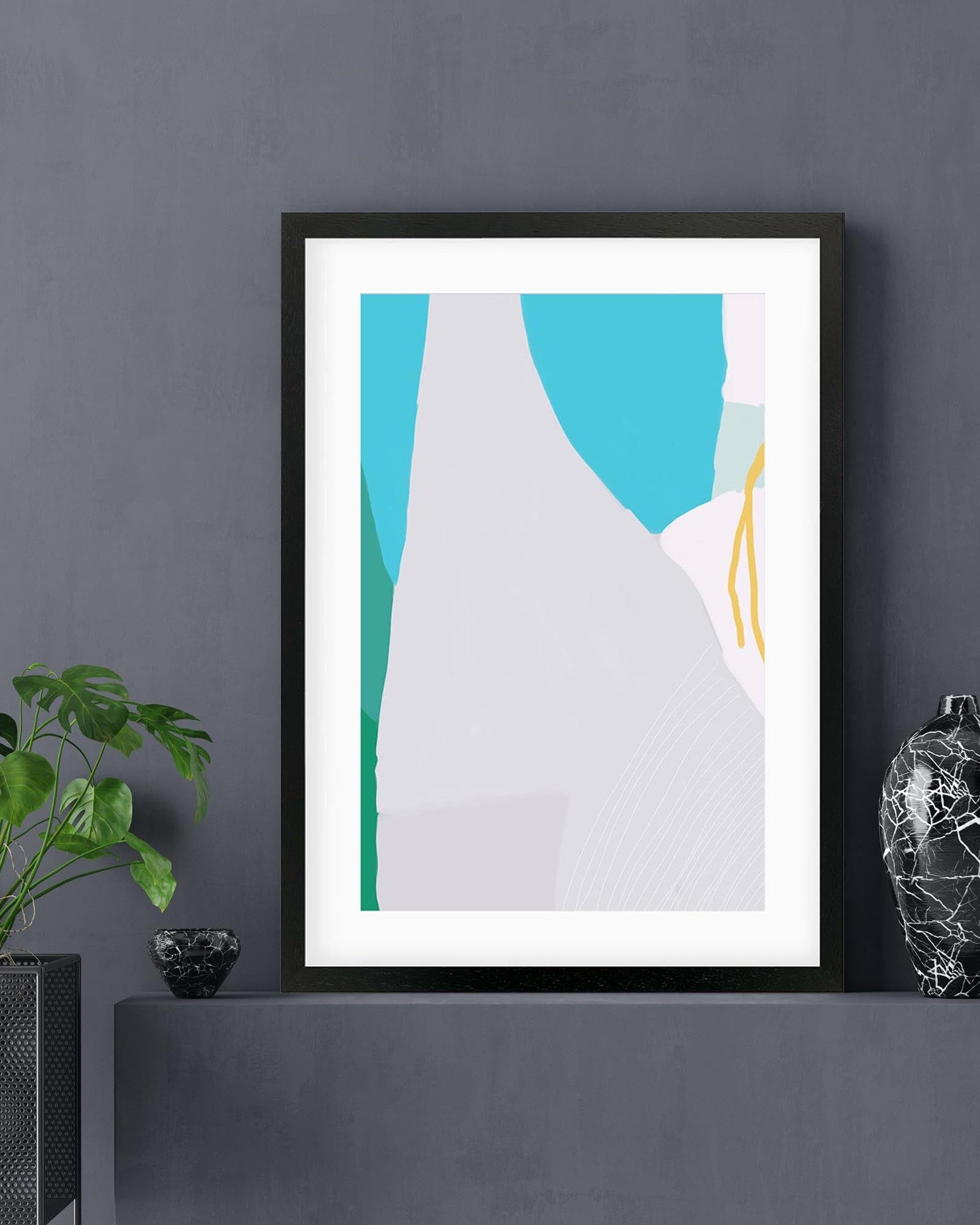 Framed abstract art piece on a dark gray wall with decorative items.